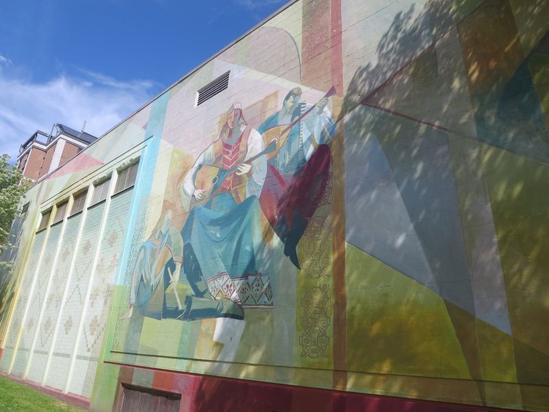 A painted panel of the mural showing figures in folk dress
