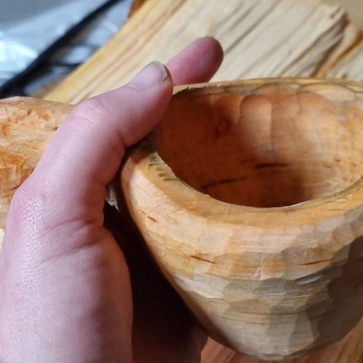 hand holding carved wood cup