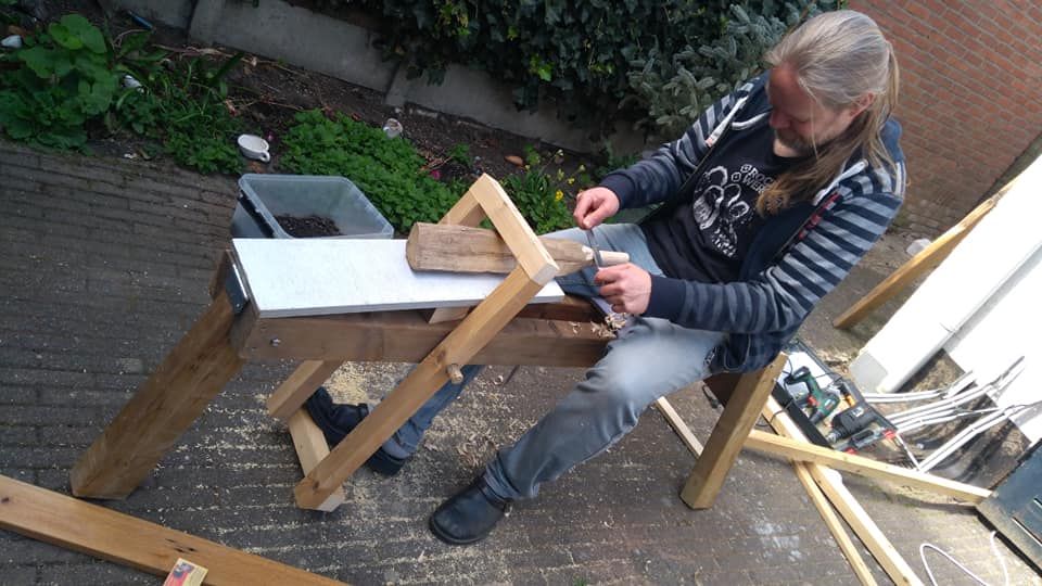 man carving wood at bench