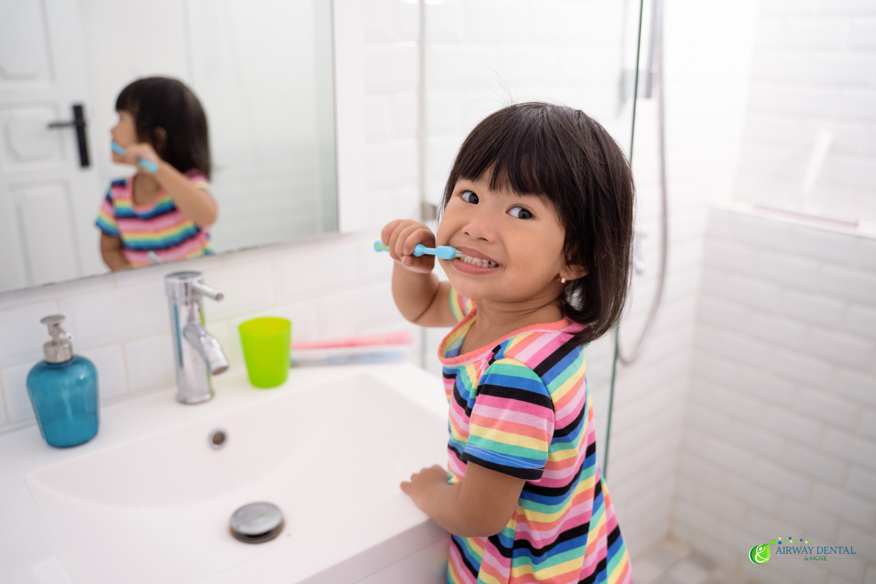 young girl brushing her teeth at the bathroom sink