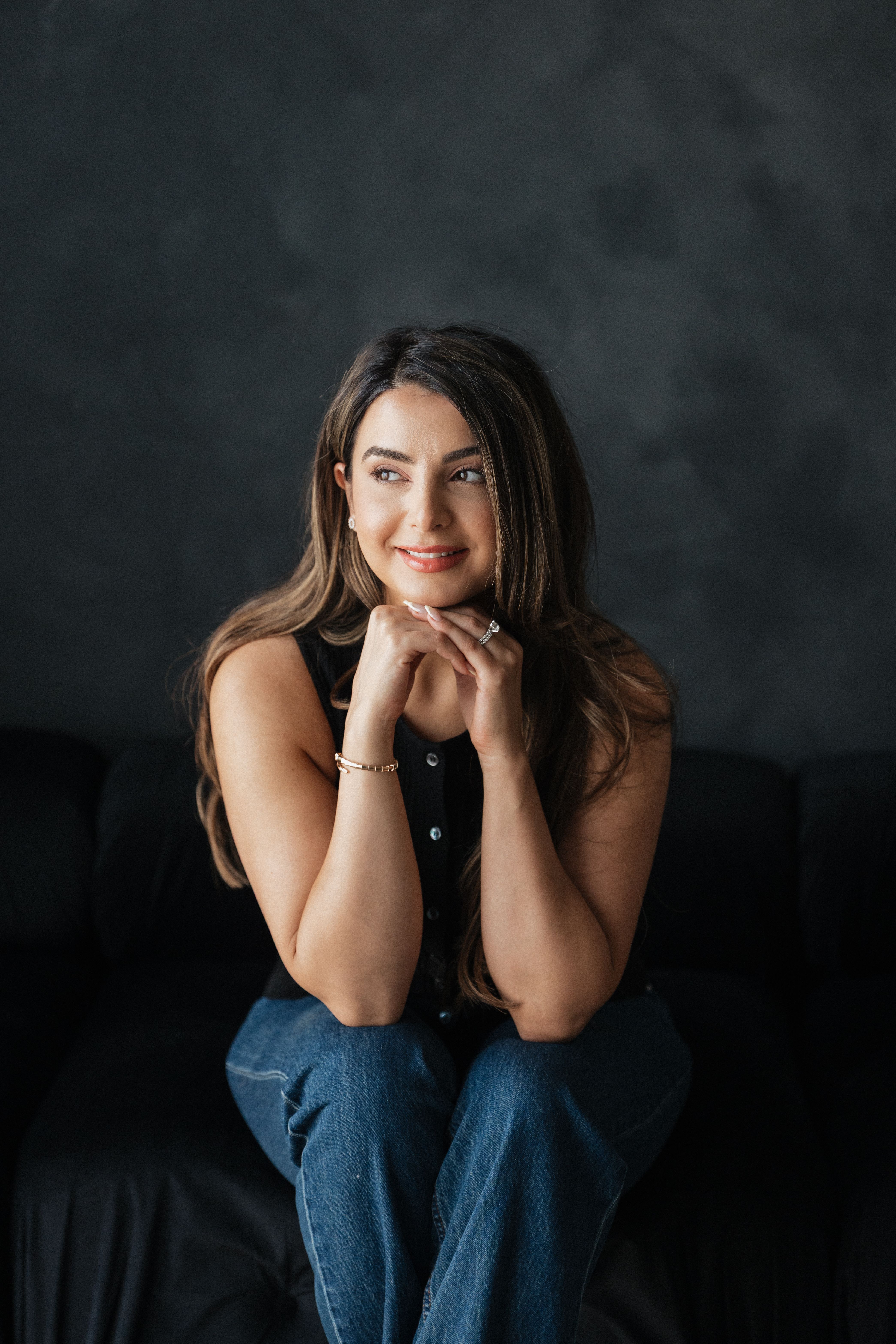 Saba, the cook behind Dine in Colors, seated against a dark backdrop