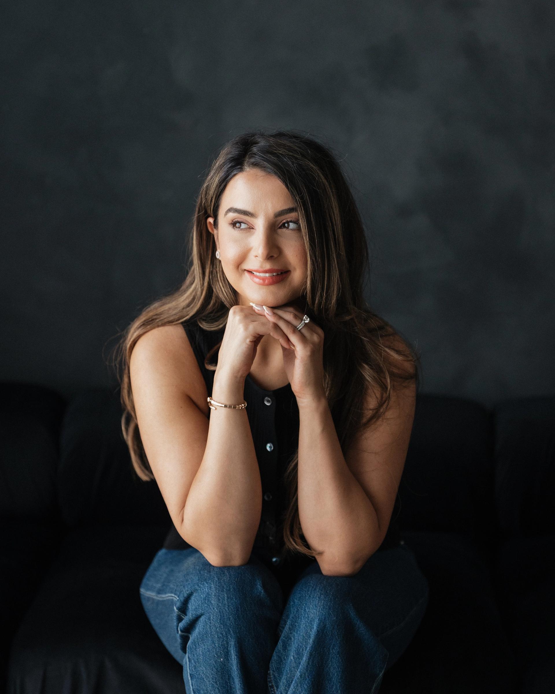 Saba, the cook behind Dine in Colors, seated against a dark backdrop