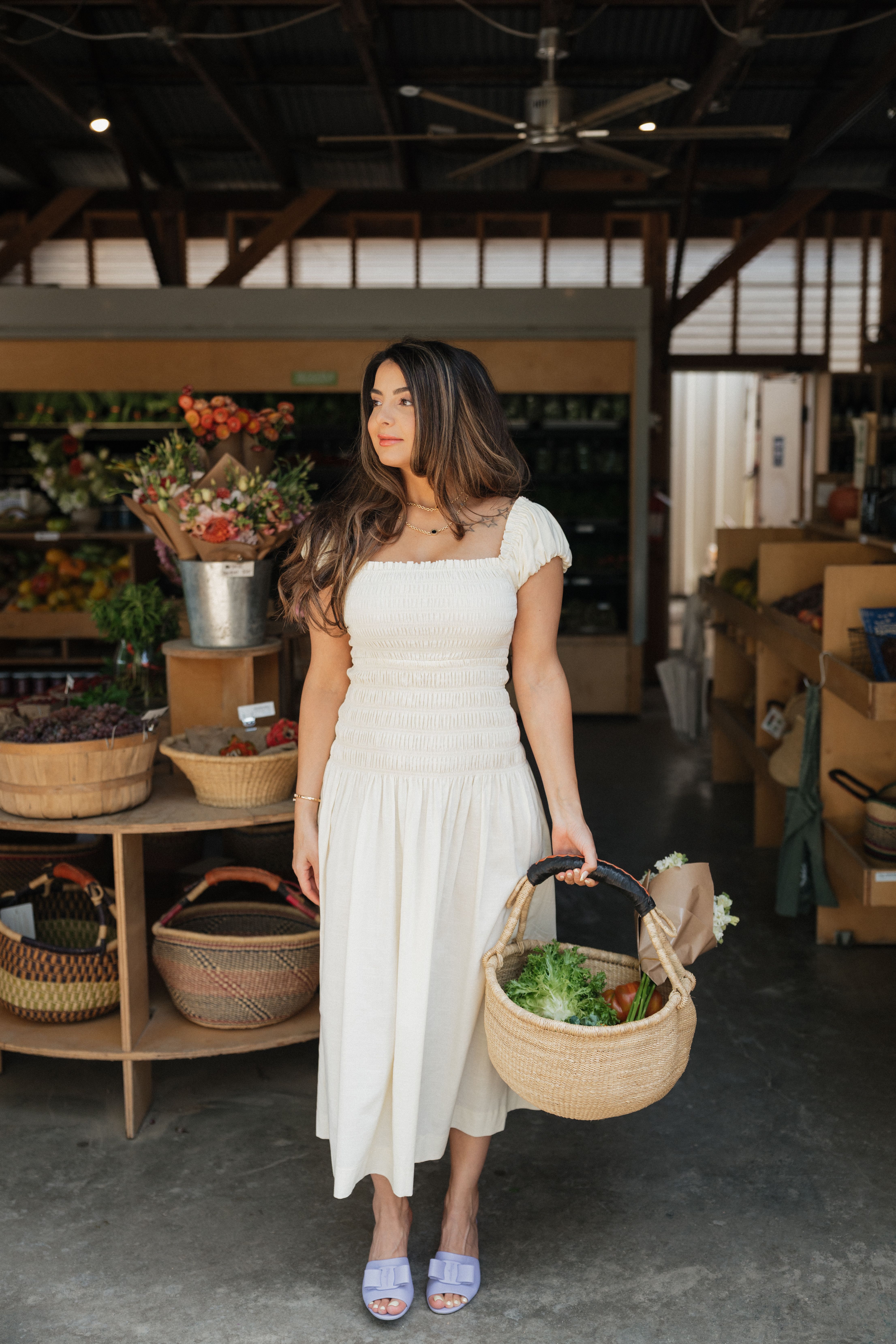 Saba holding a basket of fresh greens at a market