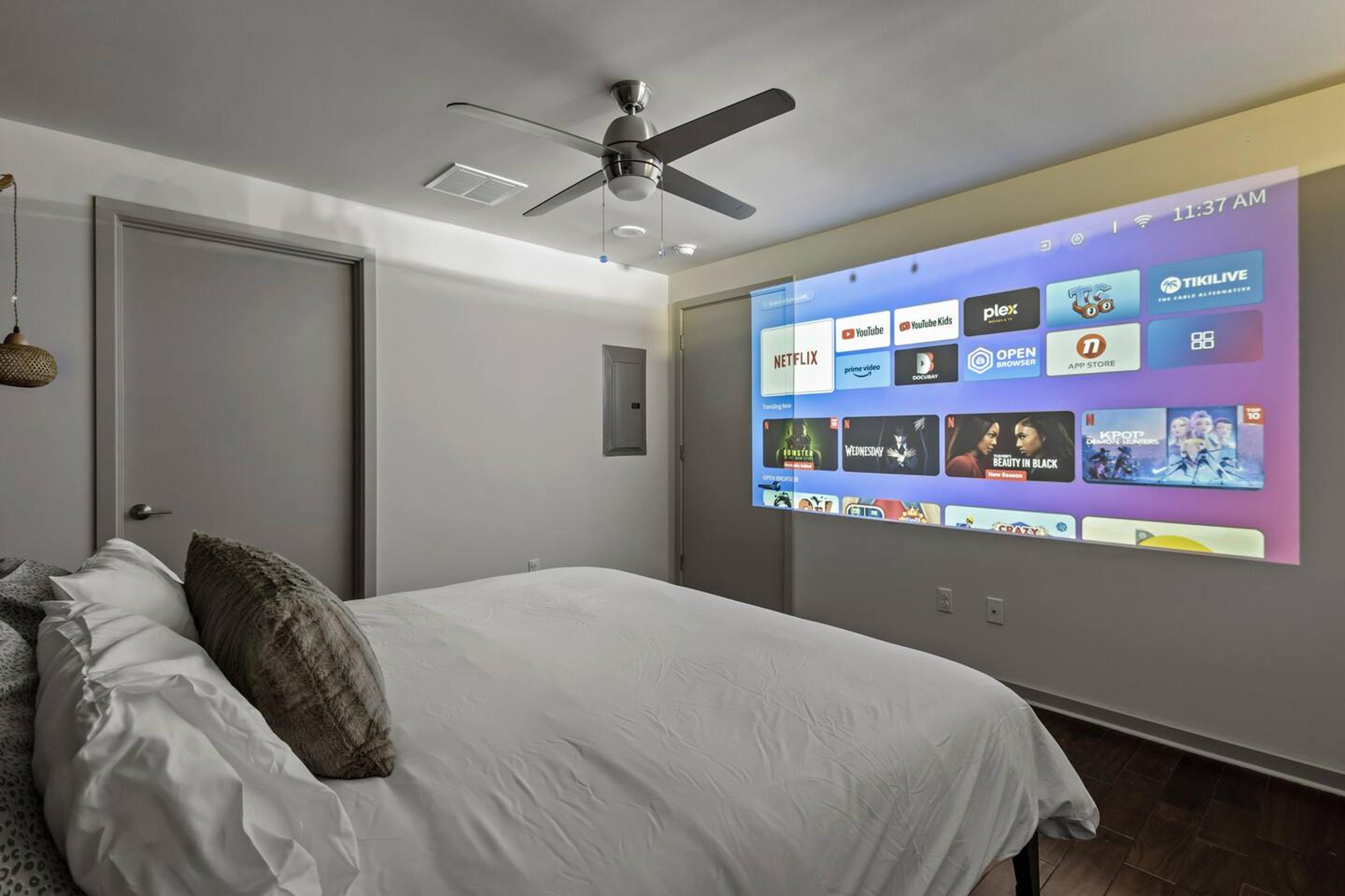 Our comfortable master bedroom with a projector to enjoy movie night with your loved ones!