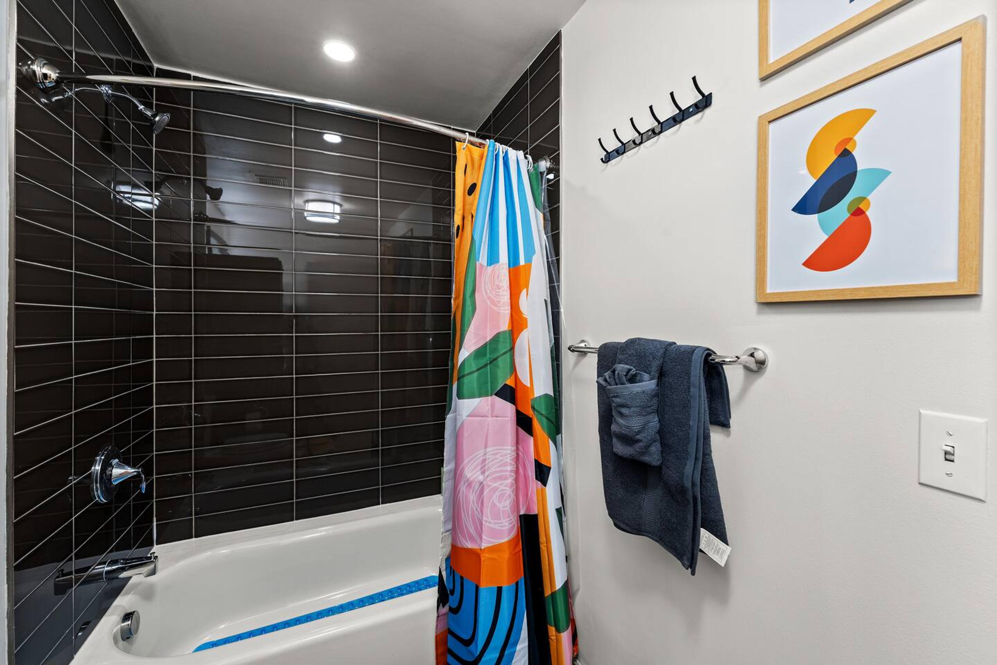 Bathroom with bathtub, toilet , vanity , big mirror, fresh towels , consumables include shampoo, conditioner, body wash, hair dryer.