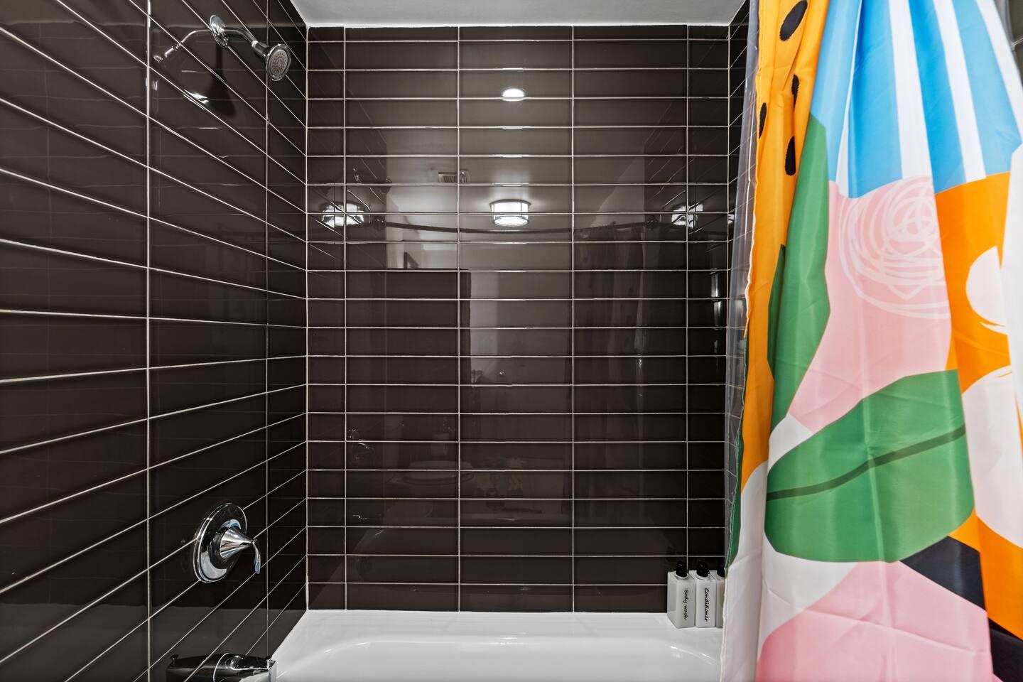 Bathroom with bathtub, toilet , vanity , big mirror, fresh towels , consumables include shampoo, conditioner, body wash, hair dryer.