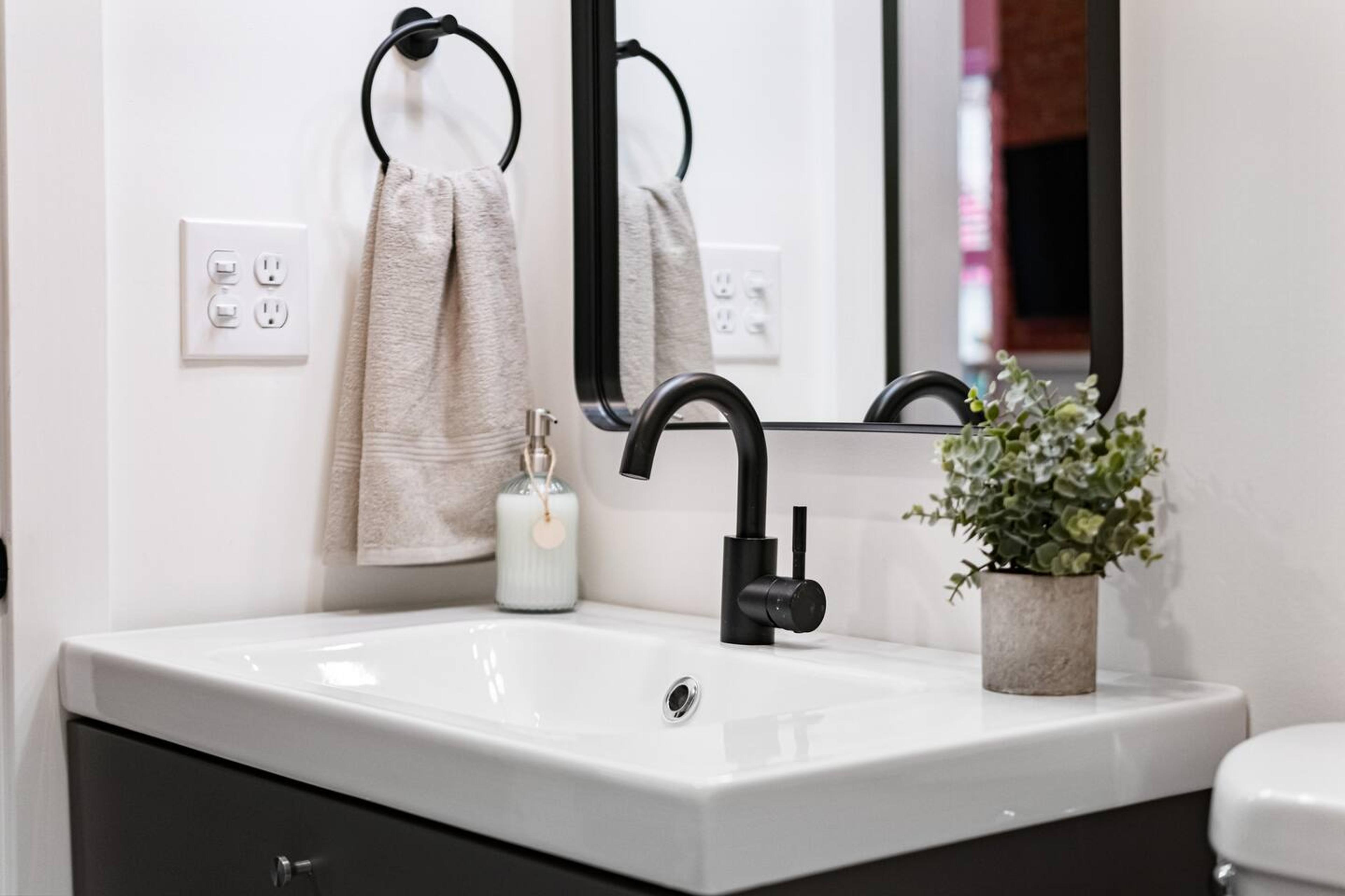 Bathroom sink with soap and towel for use.