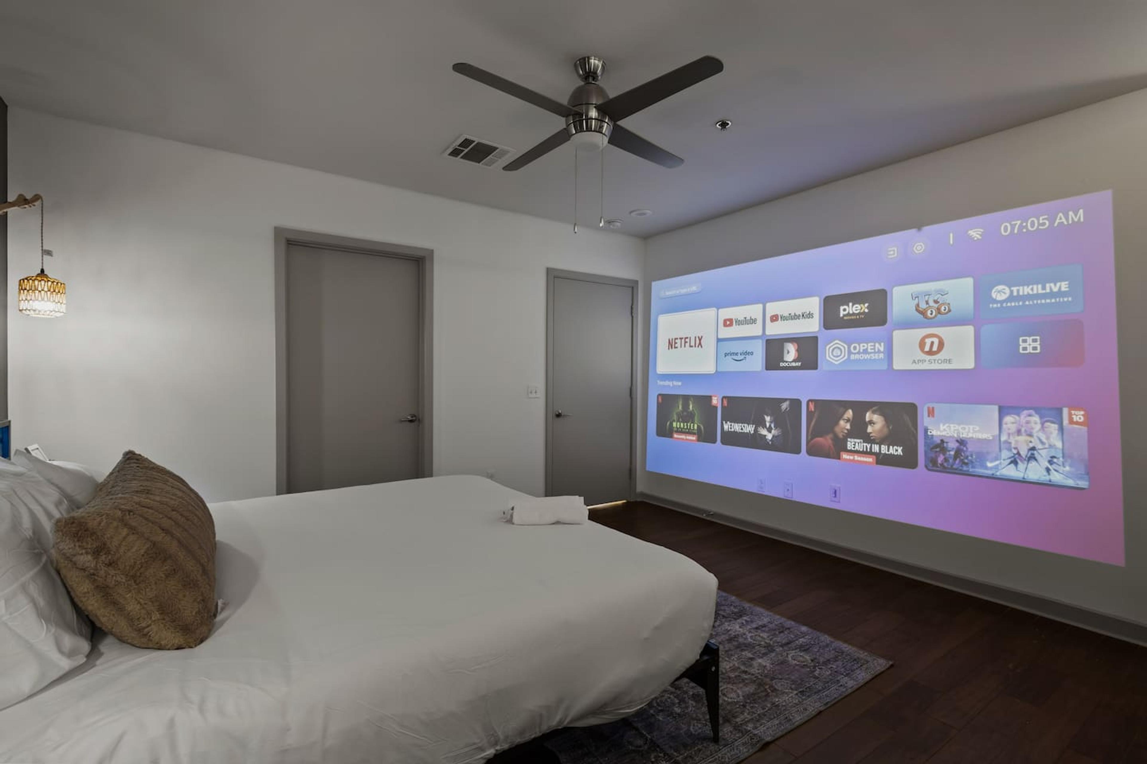 Our comfortable master bedroom with a projector to enjoy movie night with your loved ones!