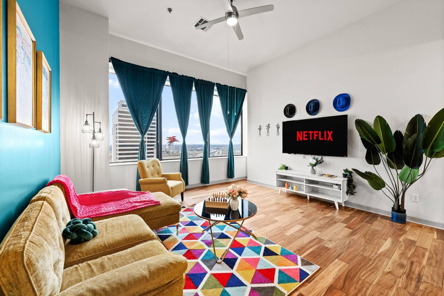 Living room equipped with comfy sofas, Tv and amenities with a view of the beautiful city!