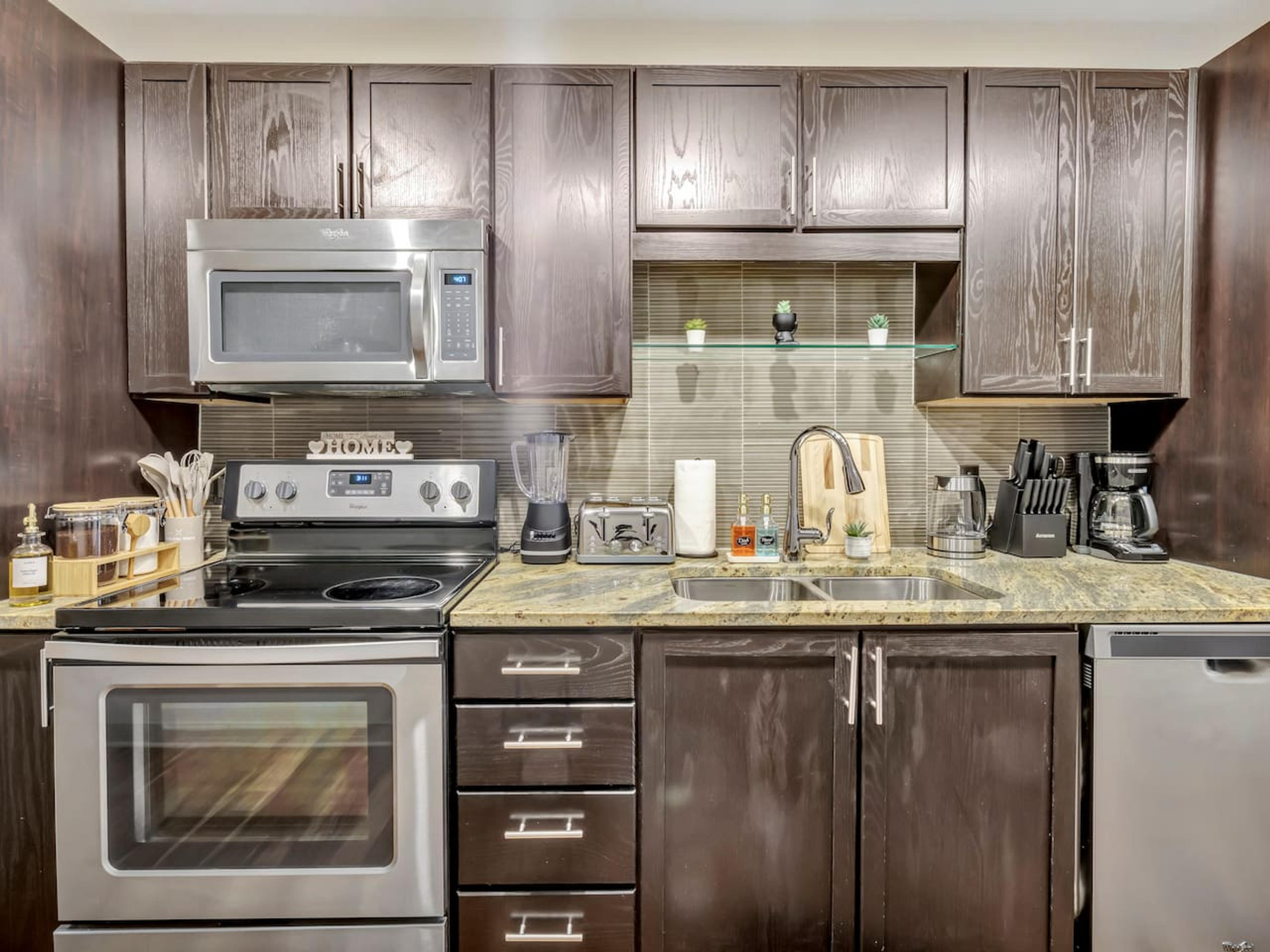 Kitchen with stainless steel appliance. Equipped with utensils and basic needs for short and mid term stay.