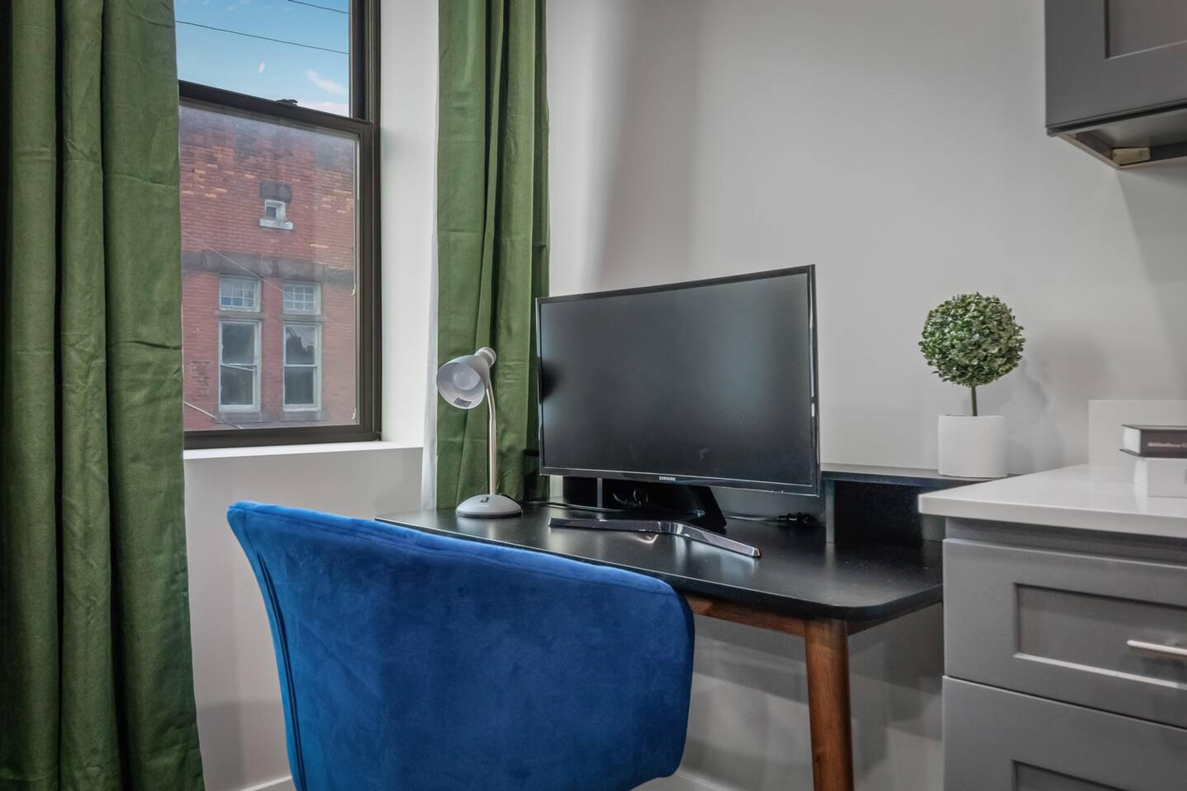 A workspace equipped with a table, chair, and monitor (By Request).