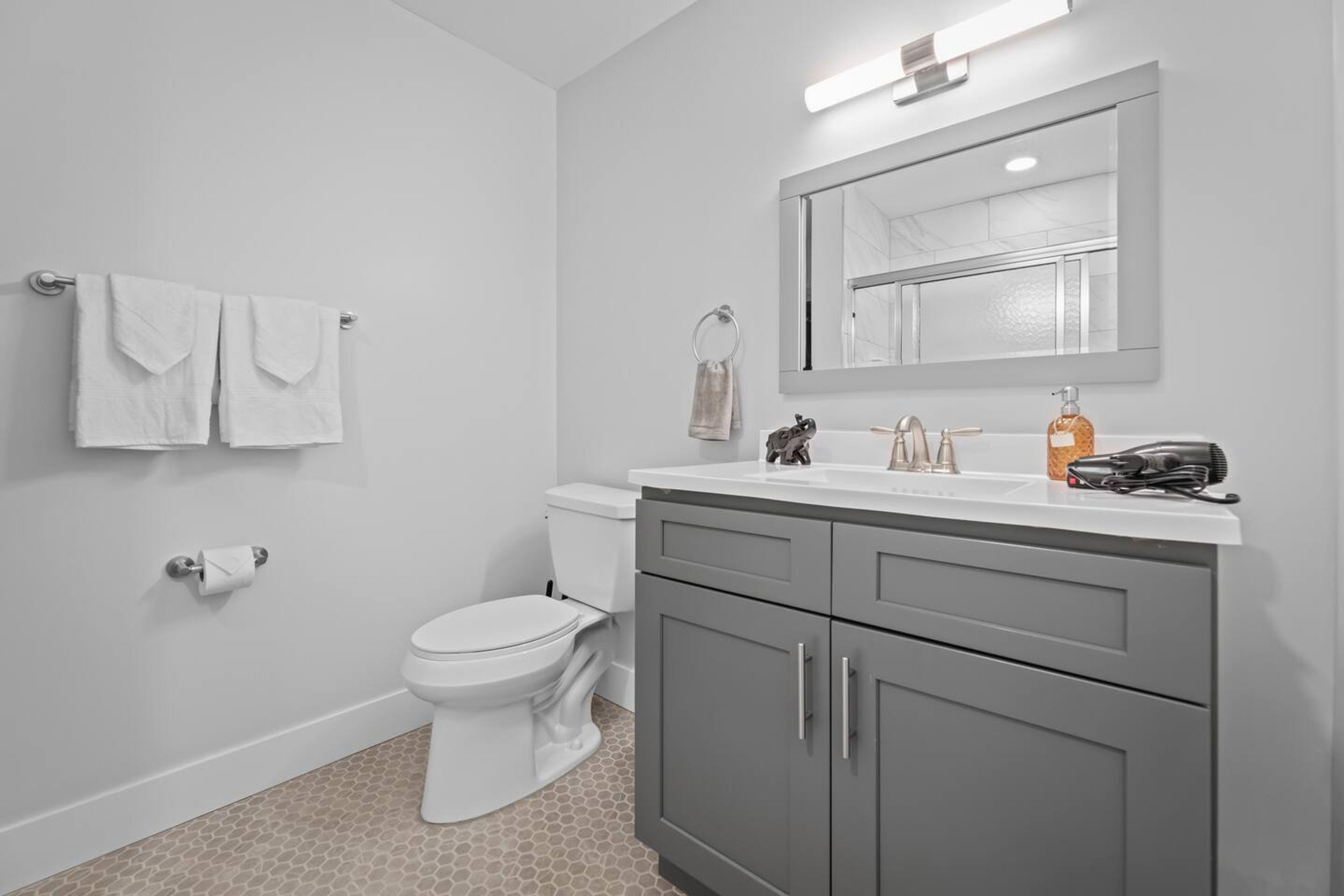 Bathroom space with clean towels, soap and a hair dryer.