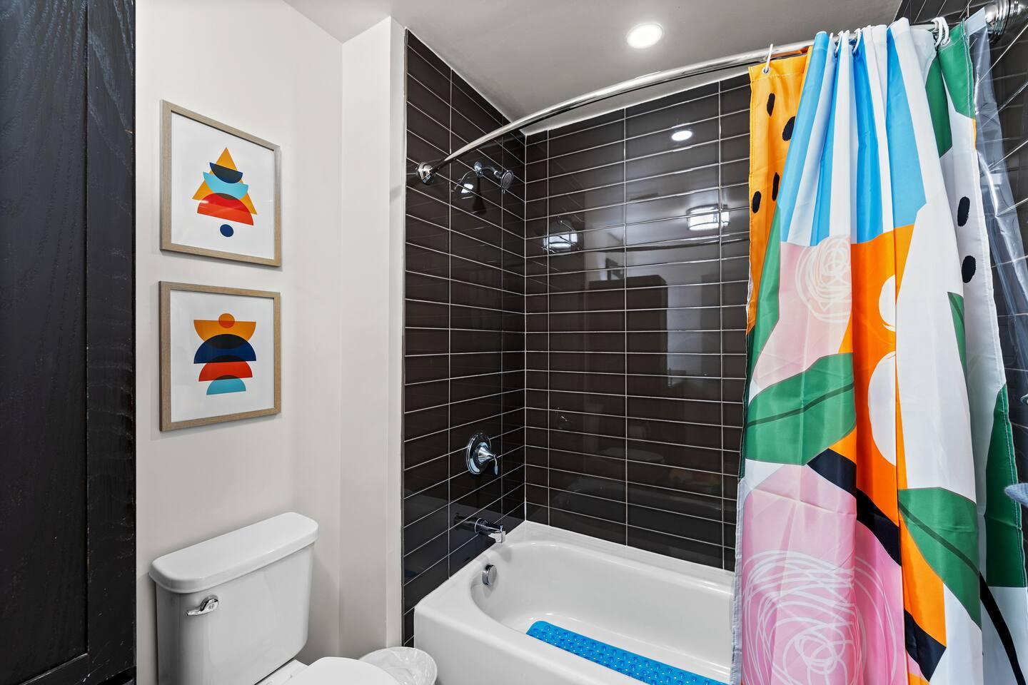 Bathroom with bathtub, toilet , vanity , big mirror, fresh towels , consumables include shampoo, conditioner, body wash, hair dryer.