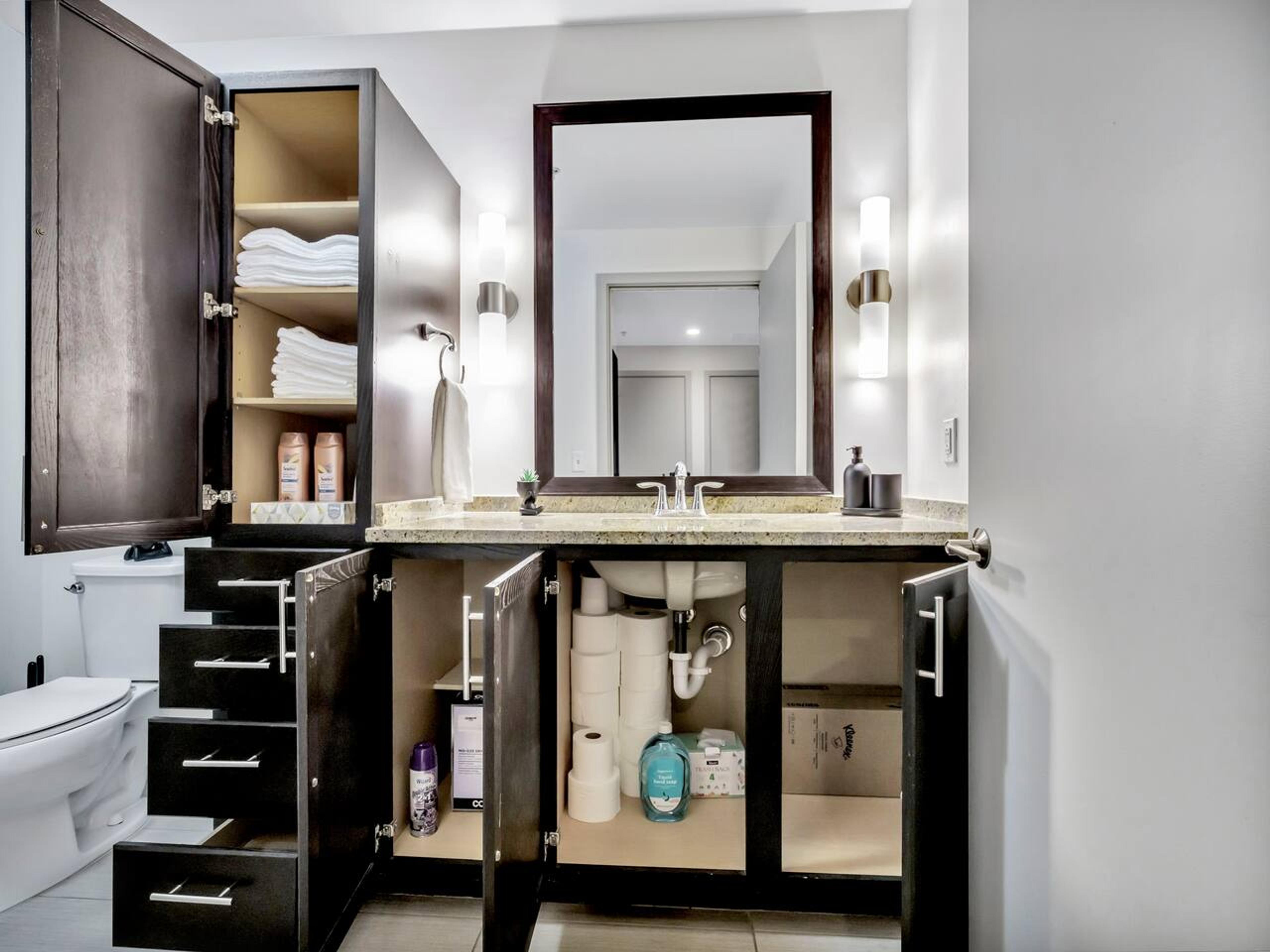 Bathroom with bathtub, toilet , vanity , big mirror, fresh towels , consumables include shampoo, conditioner, body wash, hair dryer.