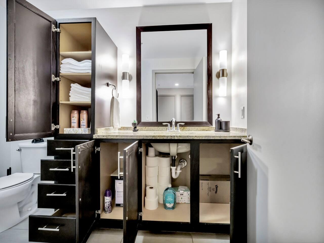 Bathroom with bathtub, toilet , vanity , big mirror, fresh towels , consumables include shampoo, conditioner, body wash, hair dryer.