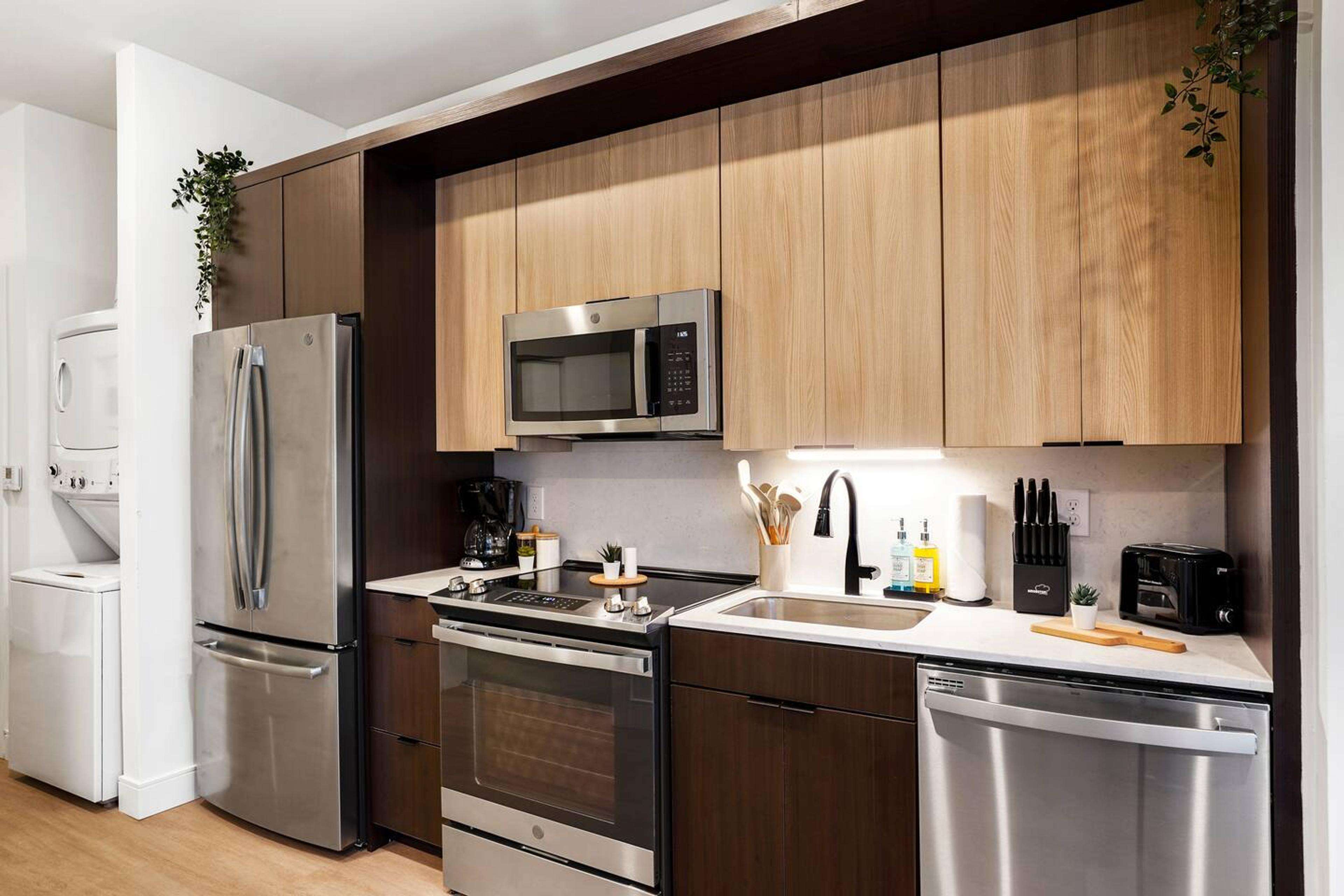Kitchen with brand new appliances, knife set and organized condiments.