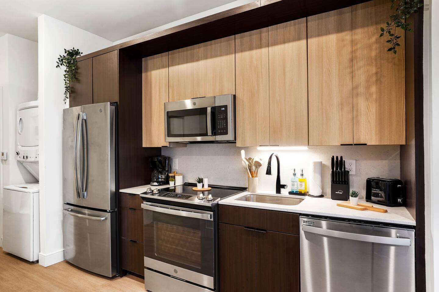 Kitchen with brand new appliances, knife set and organized condiments.