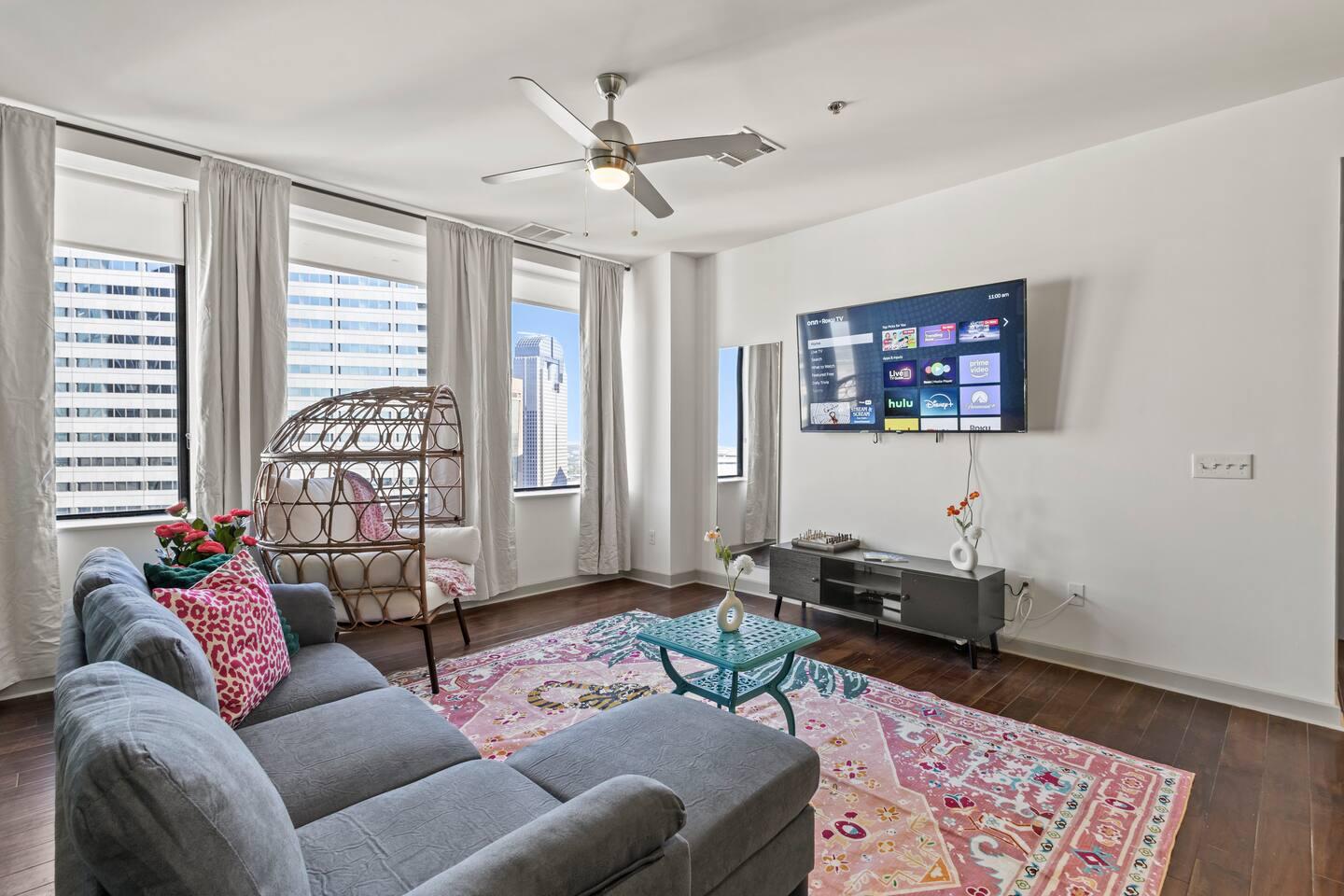 Large bright spacious living area with city view , equipped with TV, couch, pillow and throw which gives comfort and relaxing experience for the guest.