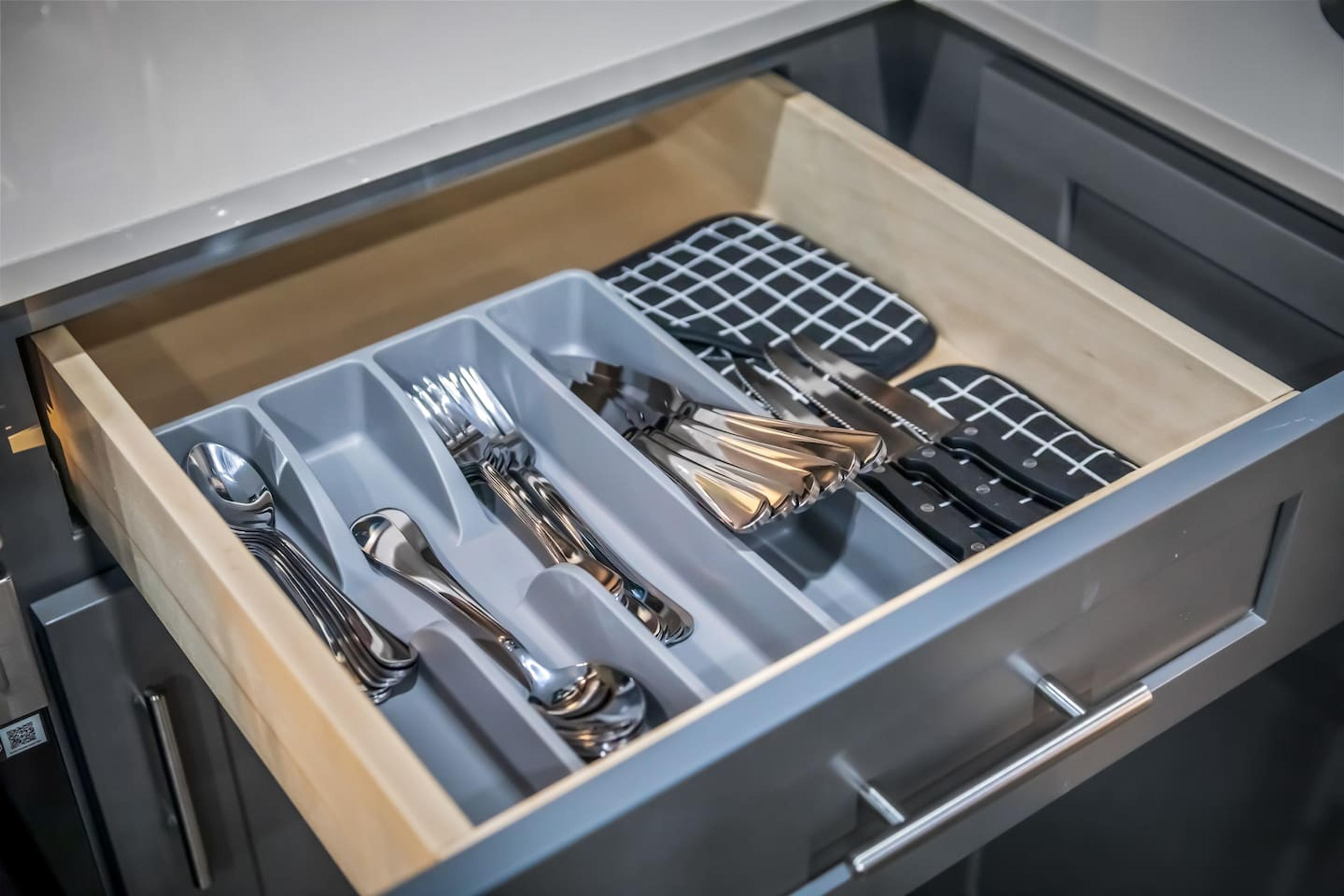 Kitchen area providing with forks, spoons, knives.