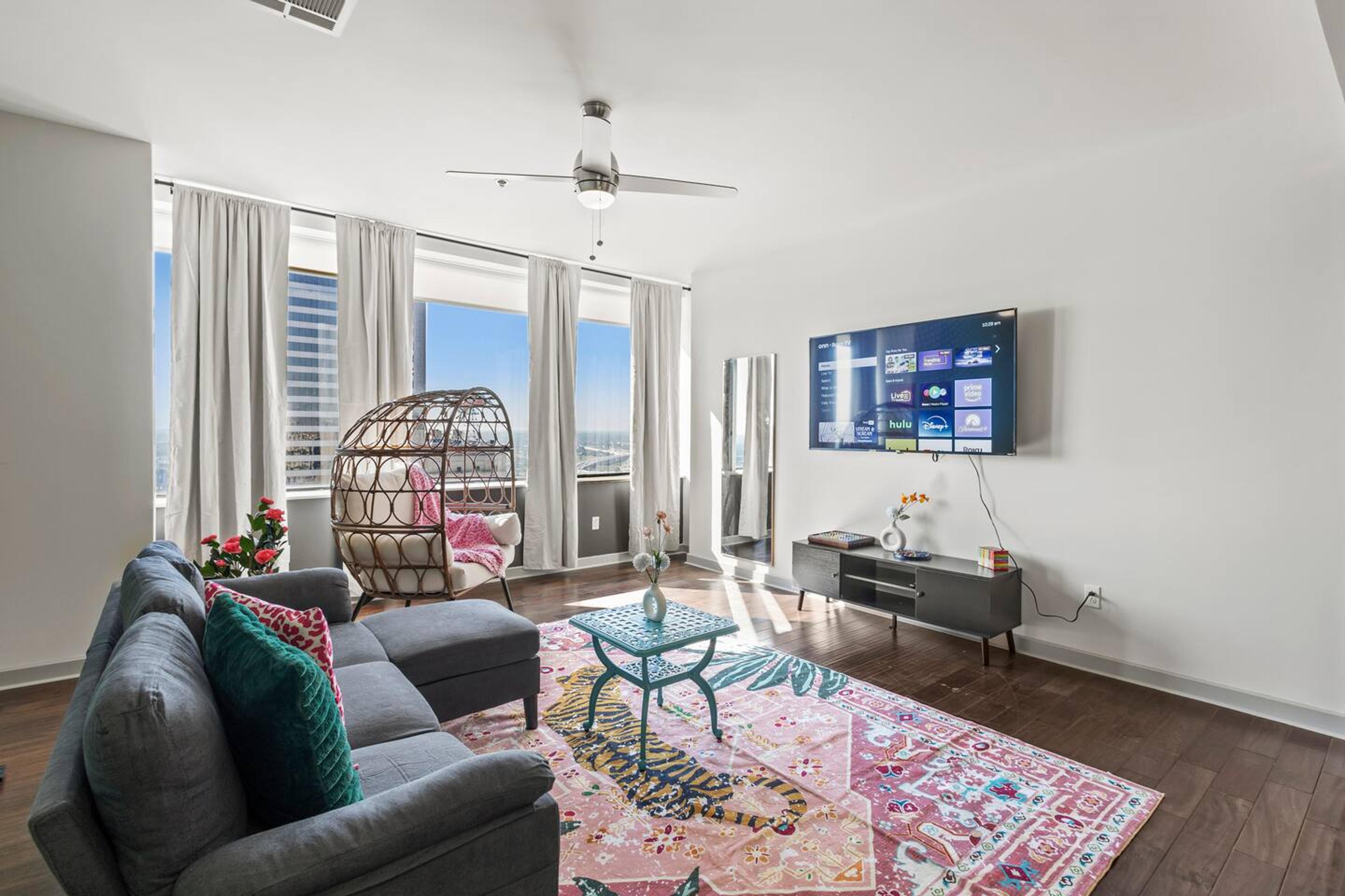 Large bright spacious living area with city view , equipped with TV, couch, pillow and throw which gives comfort and relaxing experience for the guest.