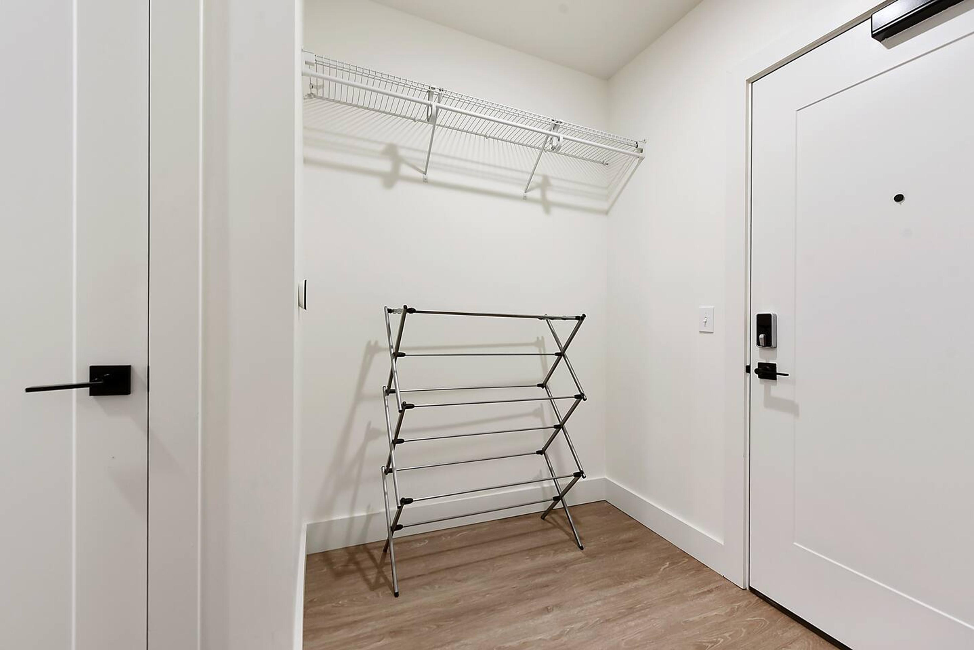 Coat hanger and a stand to dry your wet clothes behind the entrance door.