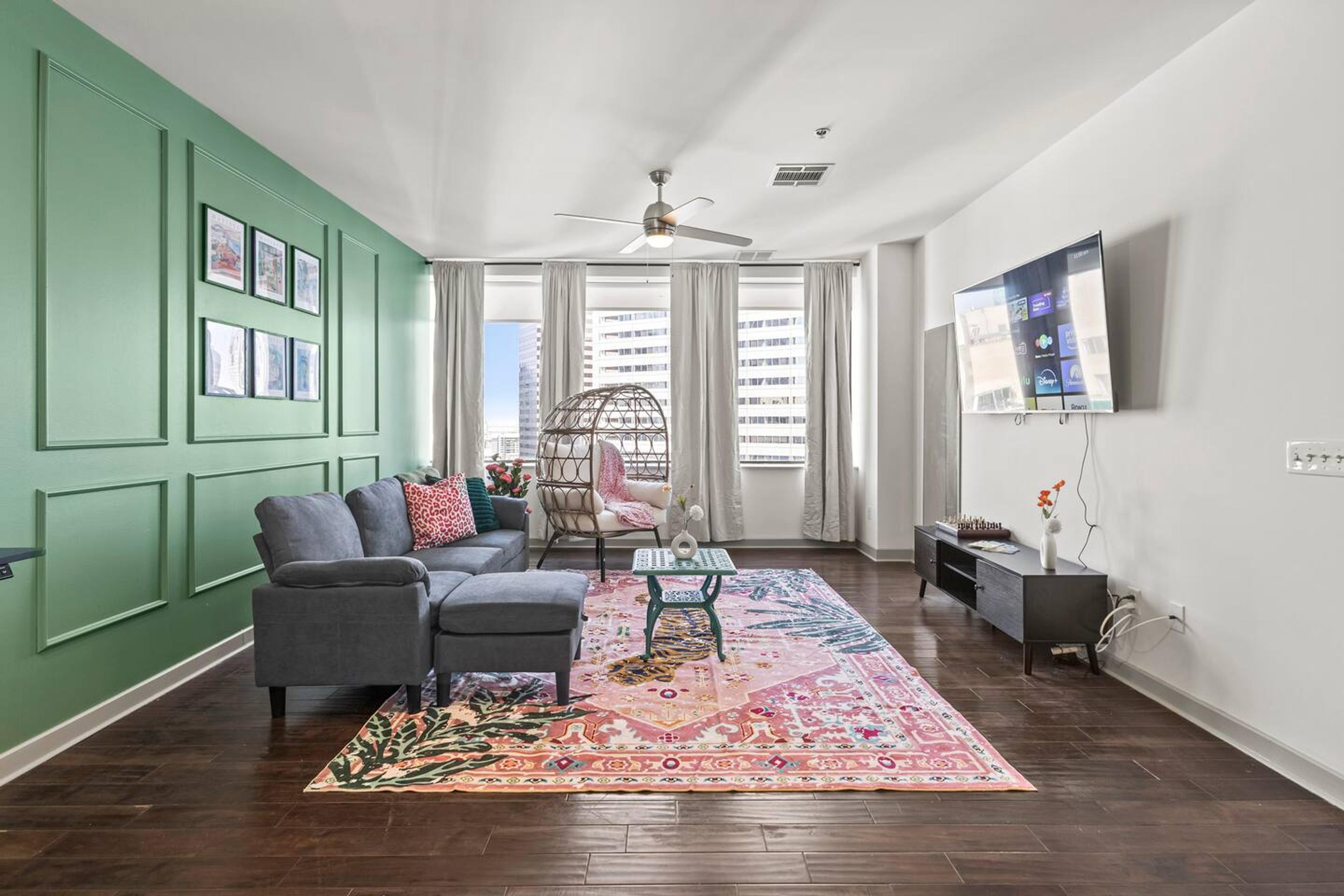 Large bright spacious living area with city view , equipped with TV, couch, pillow and throw which gives comfort and relaxing experience for the guest.