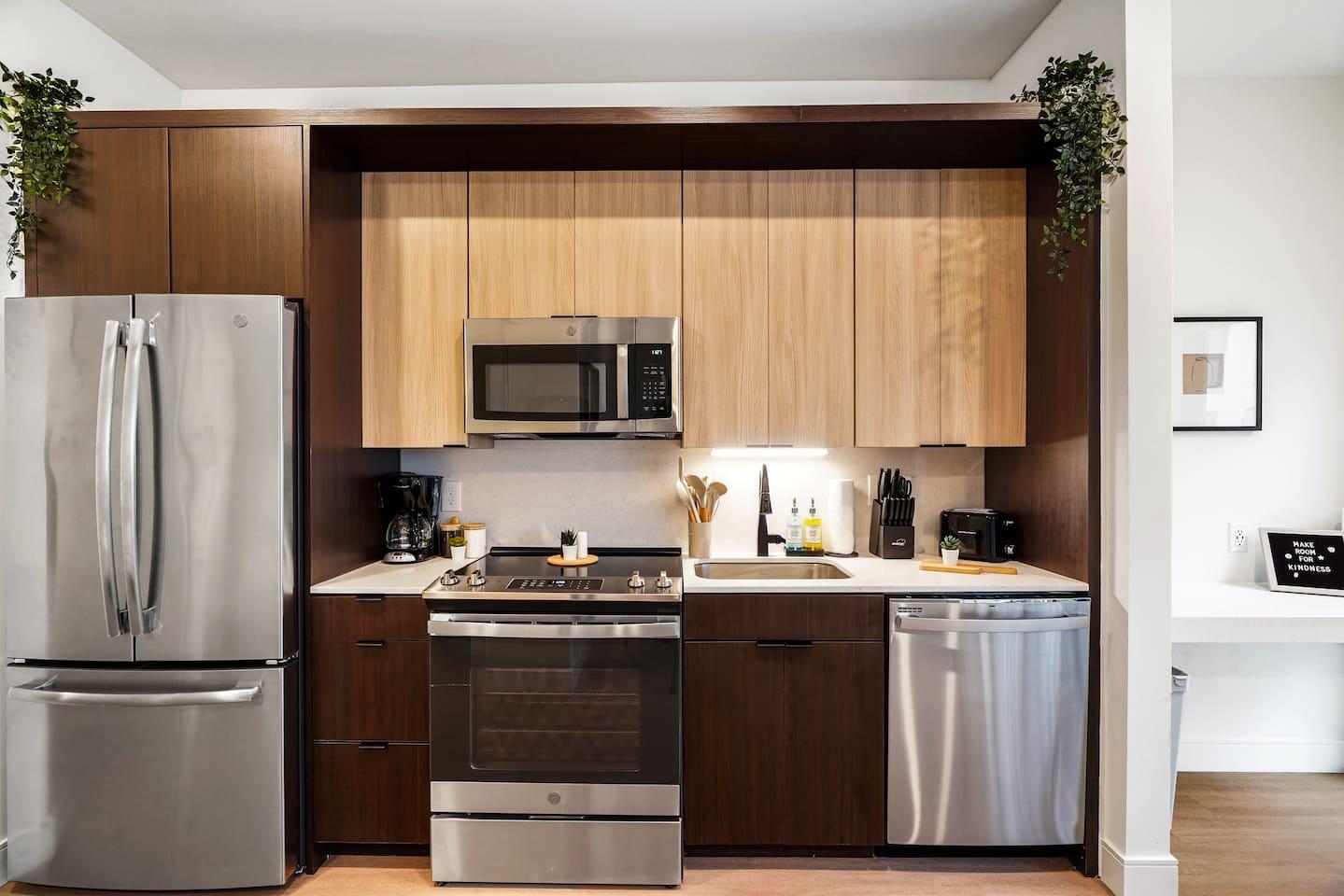 Kitchen with brand new appliances, knife set and organized condiments.
