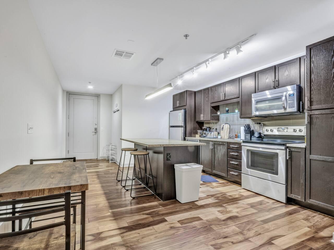Fully equipped kitchen with stainless steel appliances, microwave, gas stove, coffee machine, Knife set, bread toaster, oil, cutting board, spices, utensils, cutleries, cookware etc. with dining area.