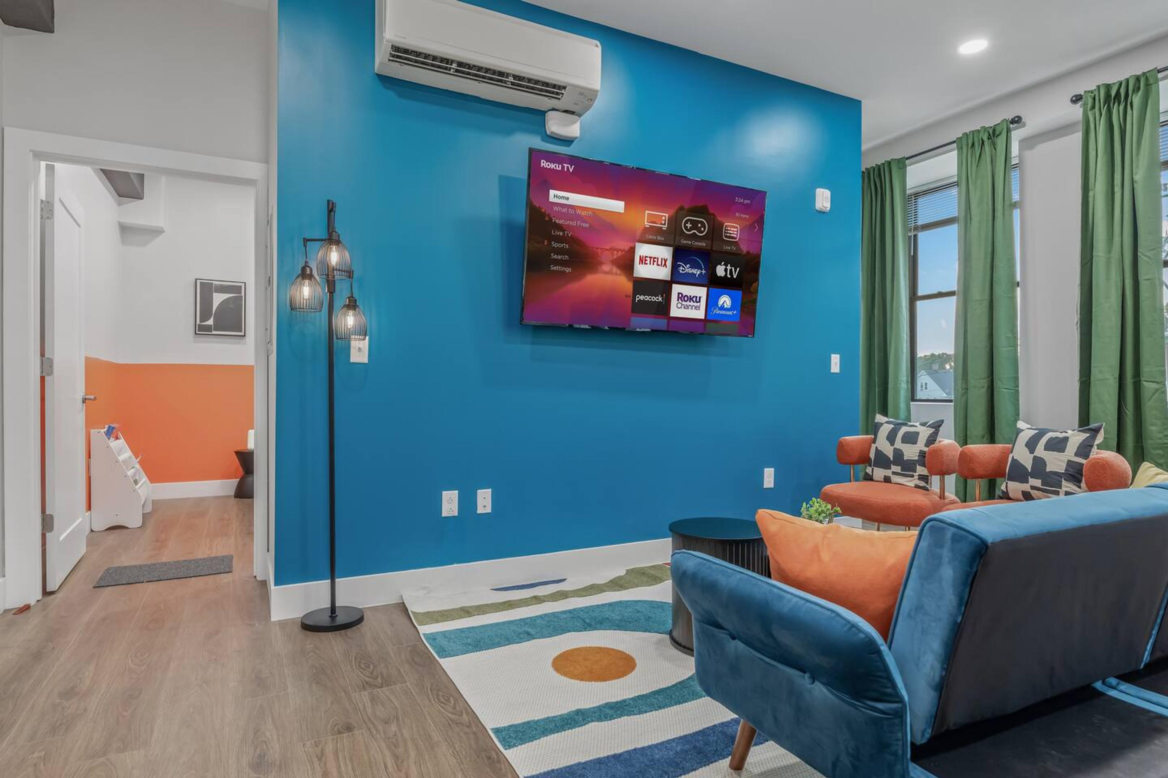 Living room with Tv, Ac, lamps, couch, comfy pillows and side table