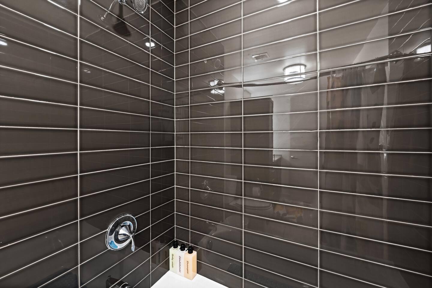 Bathroom with bathtub, toilet , vanity , big mirror, fresh towels , consumables include shampoo, conditioner, body wash, hair dryer.