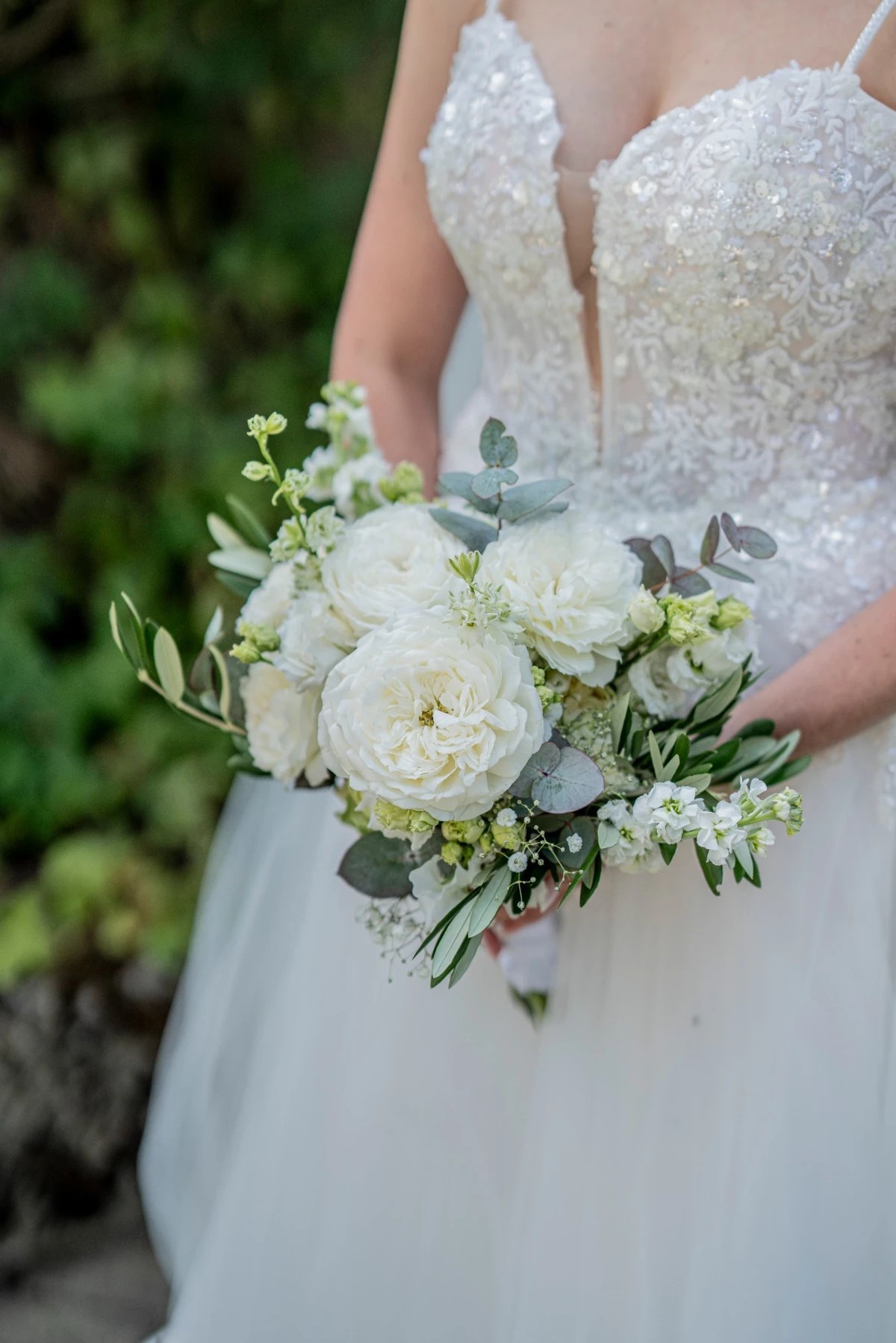 Weißer Brautstrauß mit Eukalyptus vor dem Brautkleid
