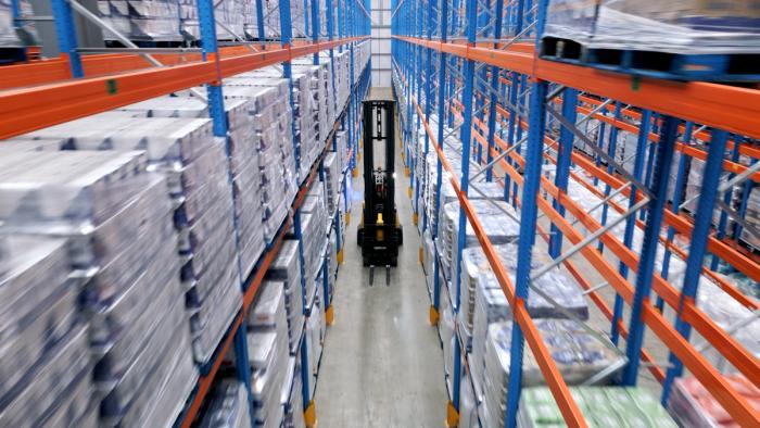 forklift truck travelling down racking aisle