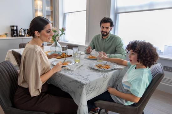 Family on holiday eating dinner together in their apartment