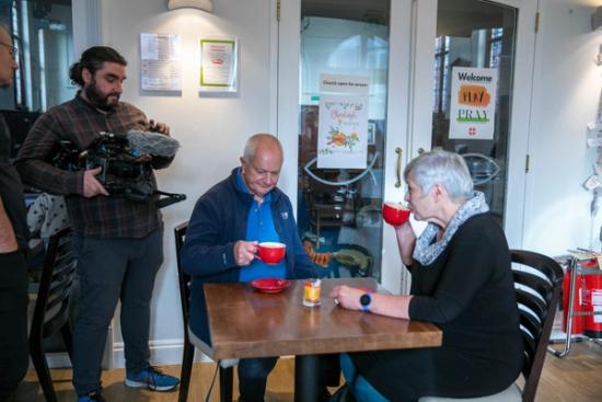 camera operator filming Chris and Lynne having a coffee