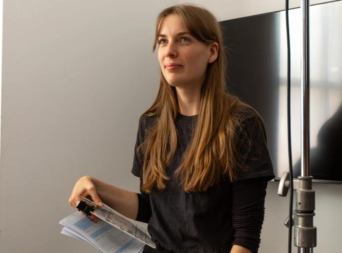 Producer on set holding clapperboard