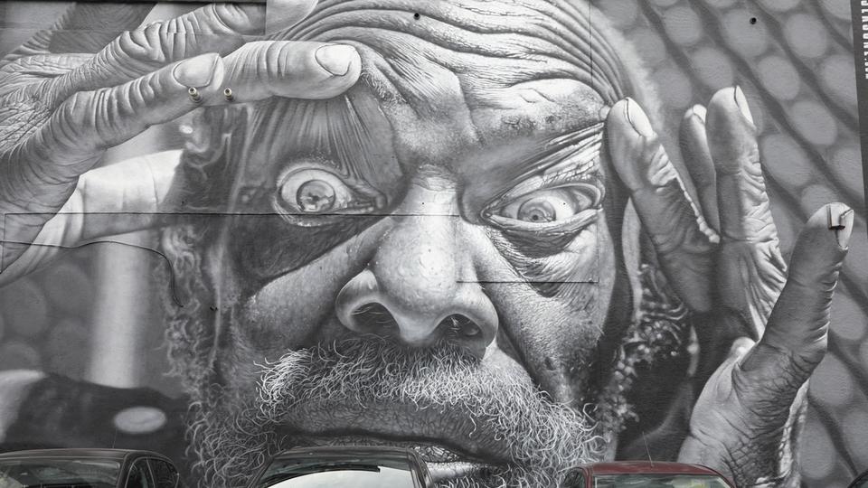 Mural in Southend of man holding his eyes open for Southend City Jam