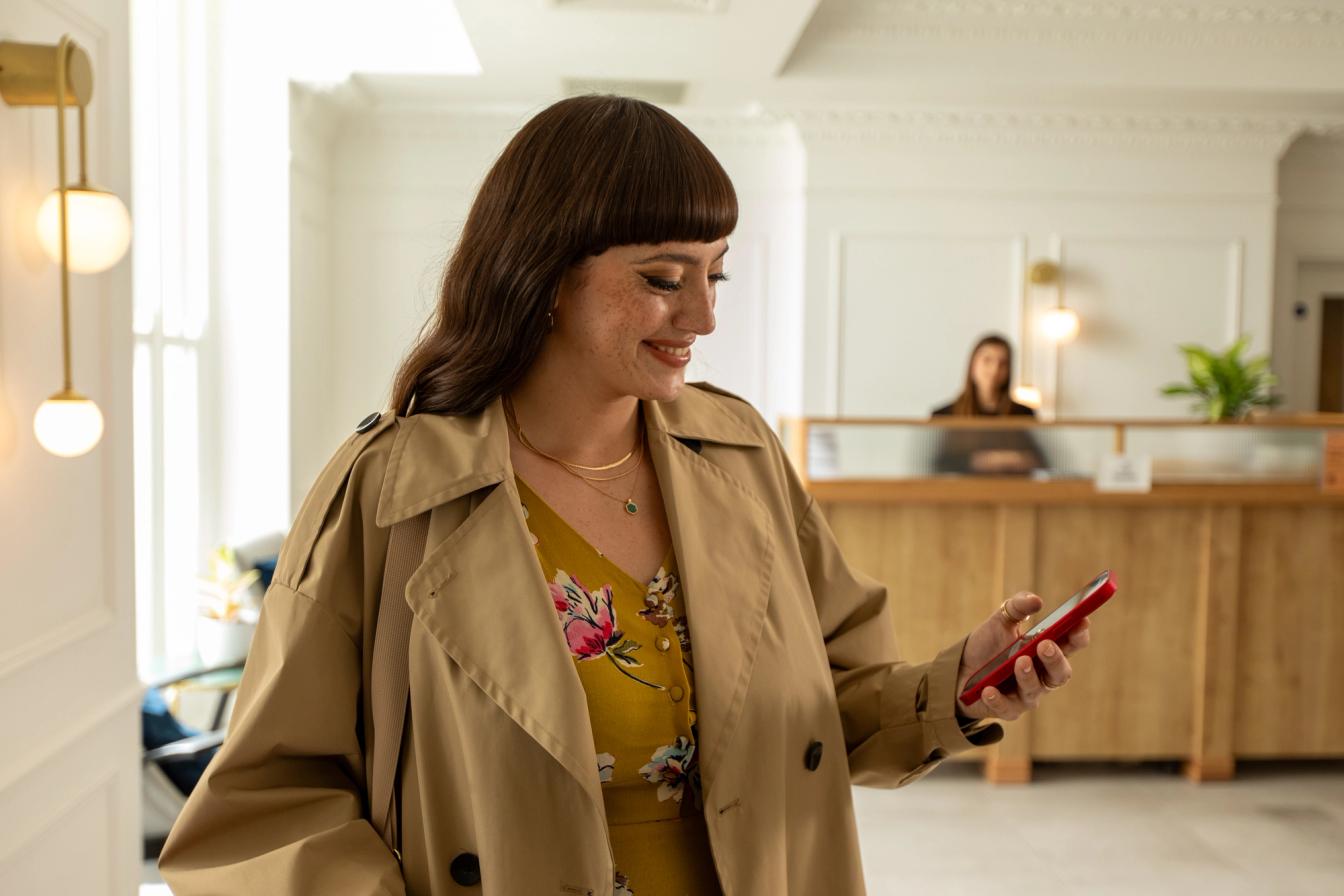 woman checking into hotel through her phone woman checking into hotel through her phone