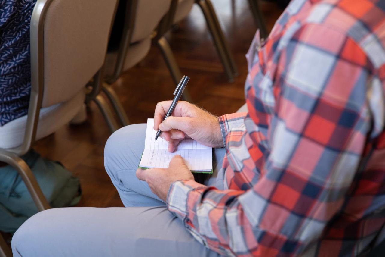 person taking notes at the conference