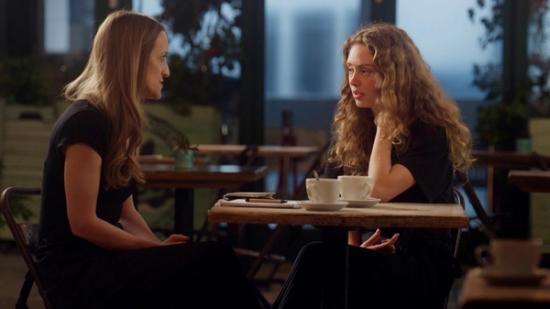 2 women sat at a table in an empty cafe