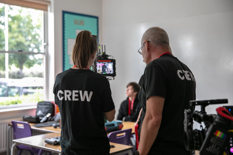 Crew members on set looking at monitor