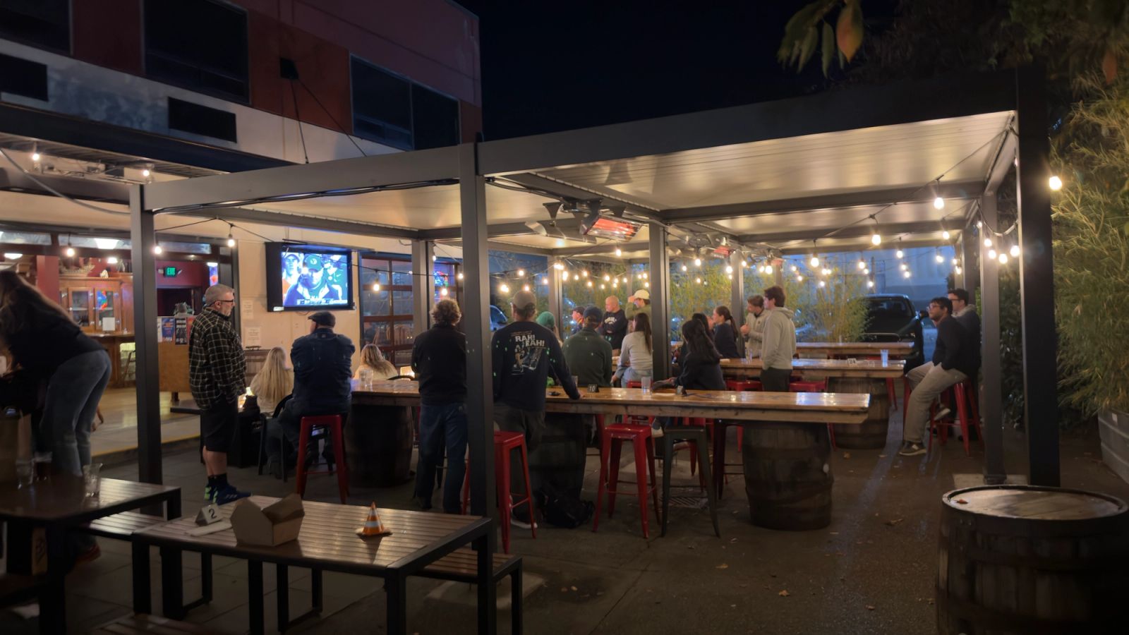 Guests on patio on a Saturday night watching football game on outside TV