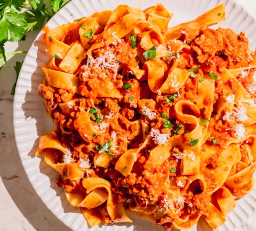 Maui Nui ground venison in a red sauce pasta served with grated parmesan and green parsley toppings.