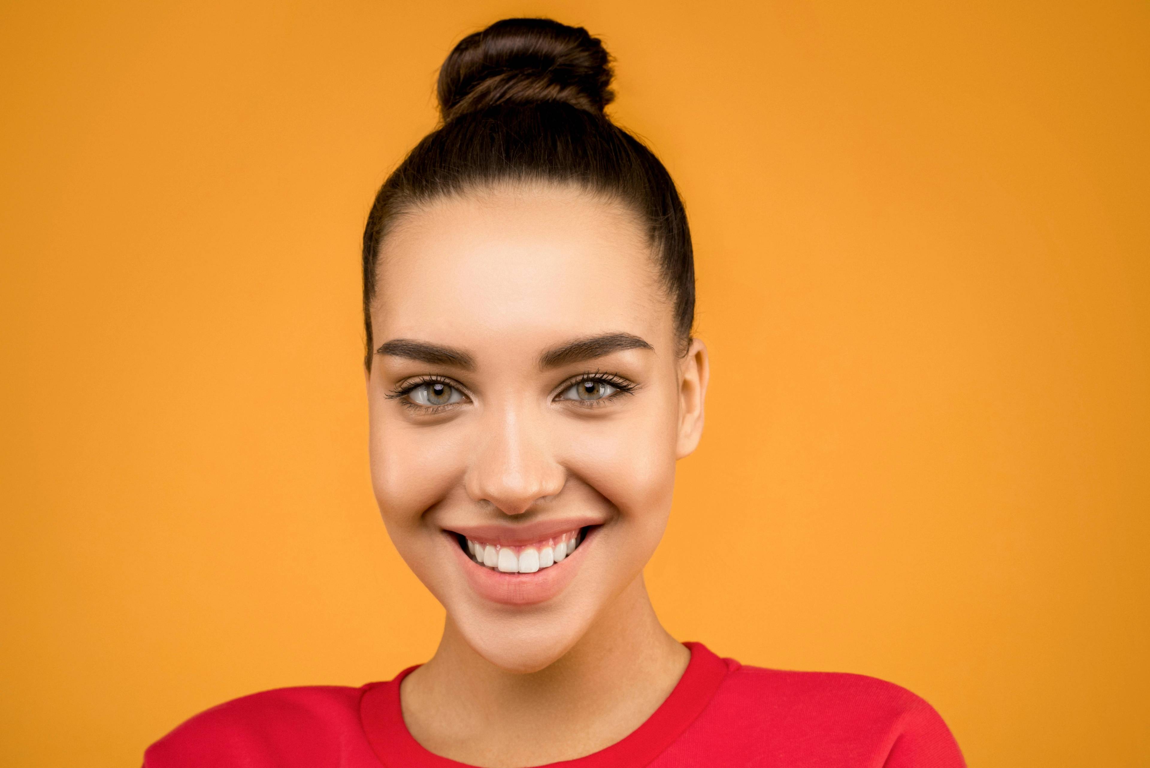 young woman smiling with youthful fuller smooth skin