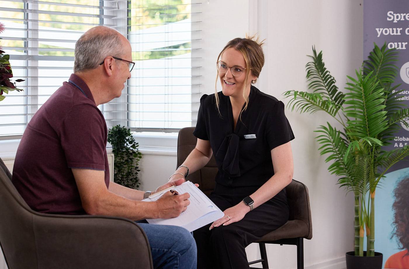 patient talking to a receptionist in a dental surgery waiting room