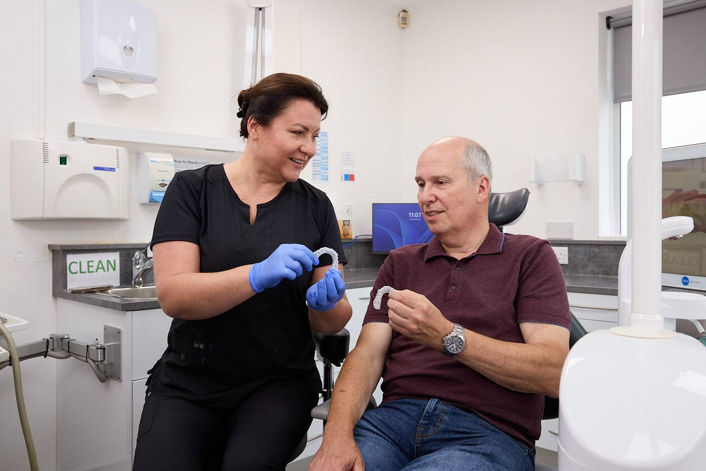a dental mouthguard being held by a dentist with PPE on