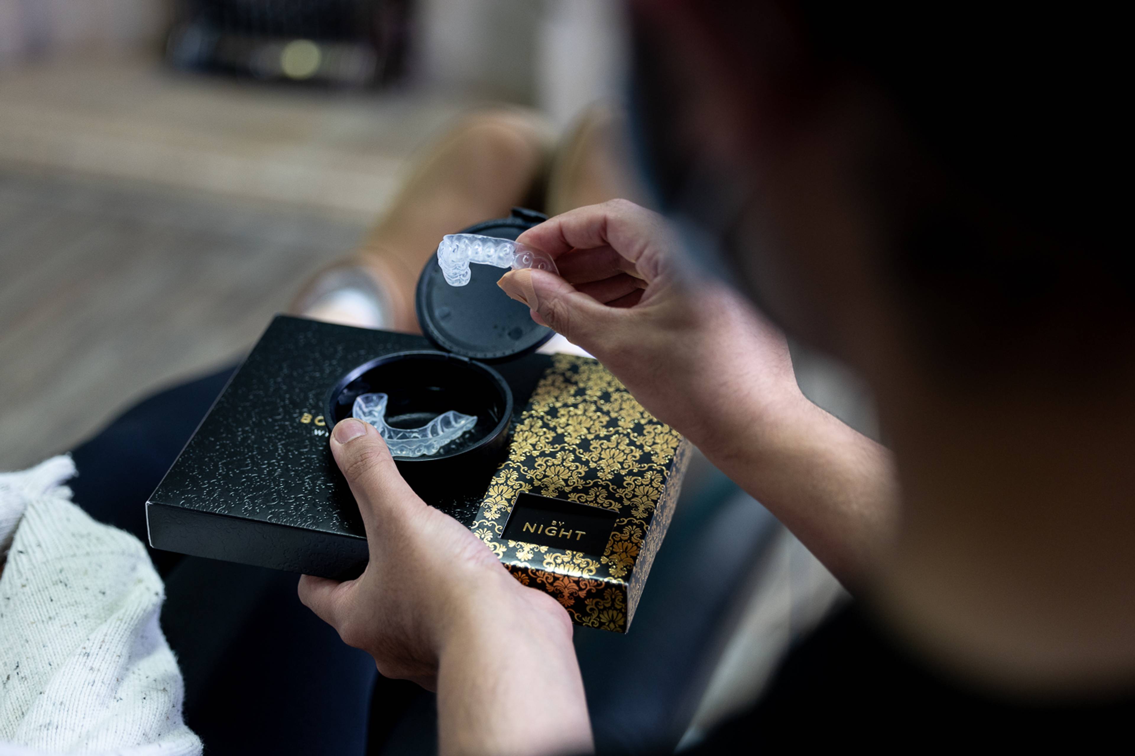 patient in dental surgery being shown whitening trays by dental nurse