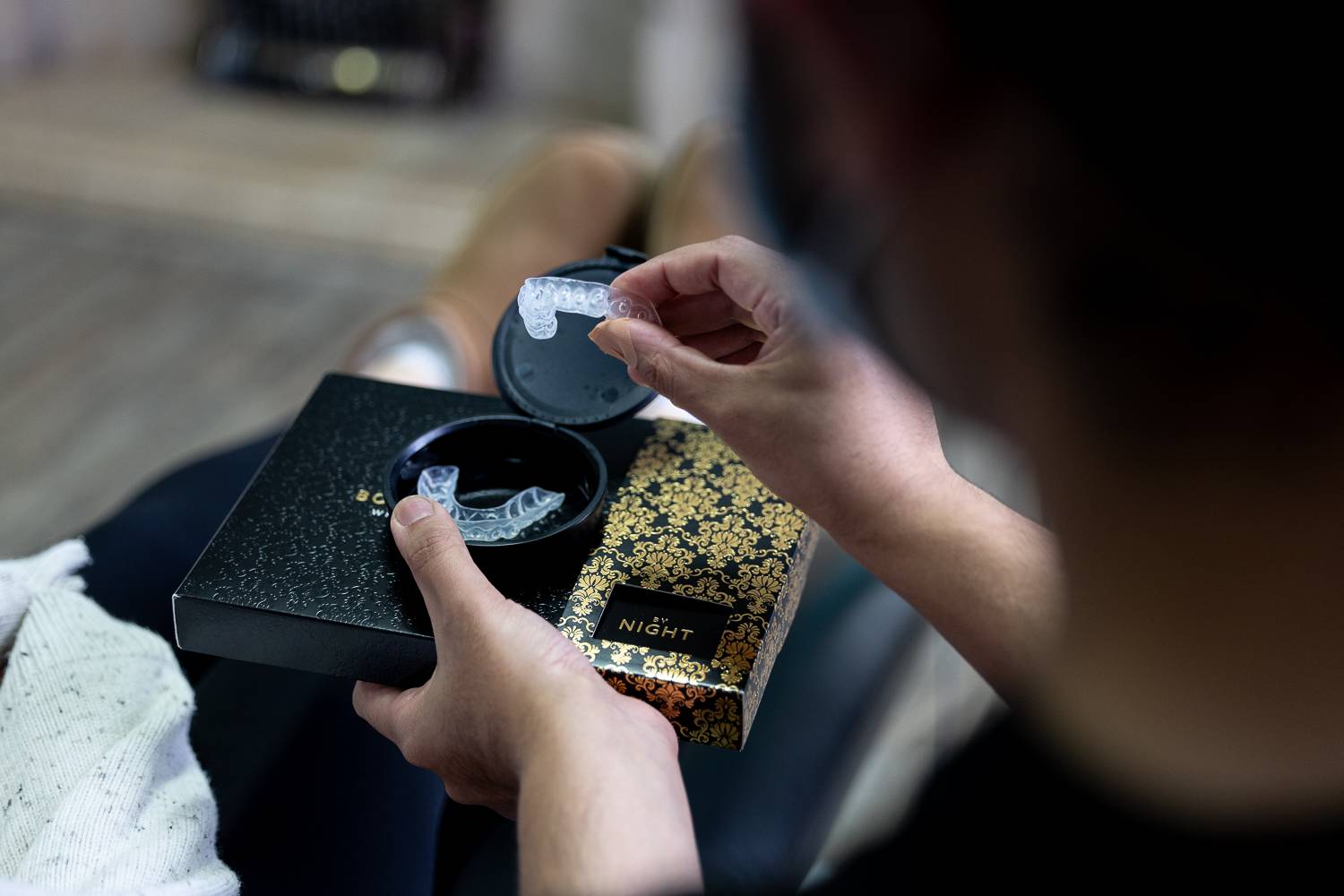 patient in dental surgery being shown whitening trays by dental nurse