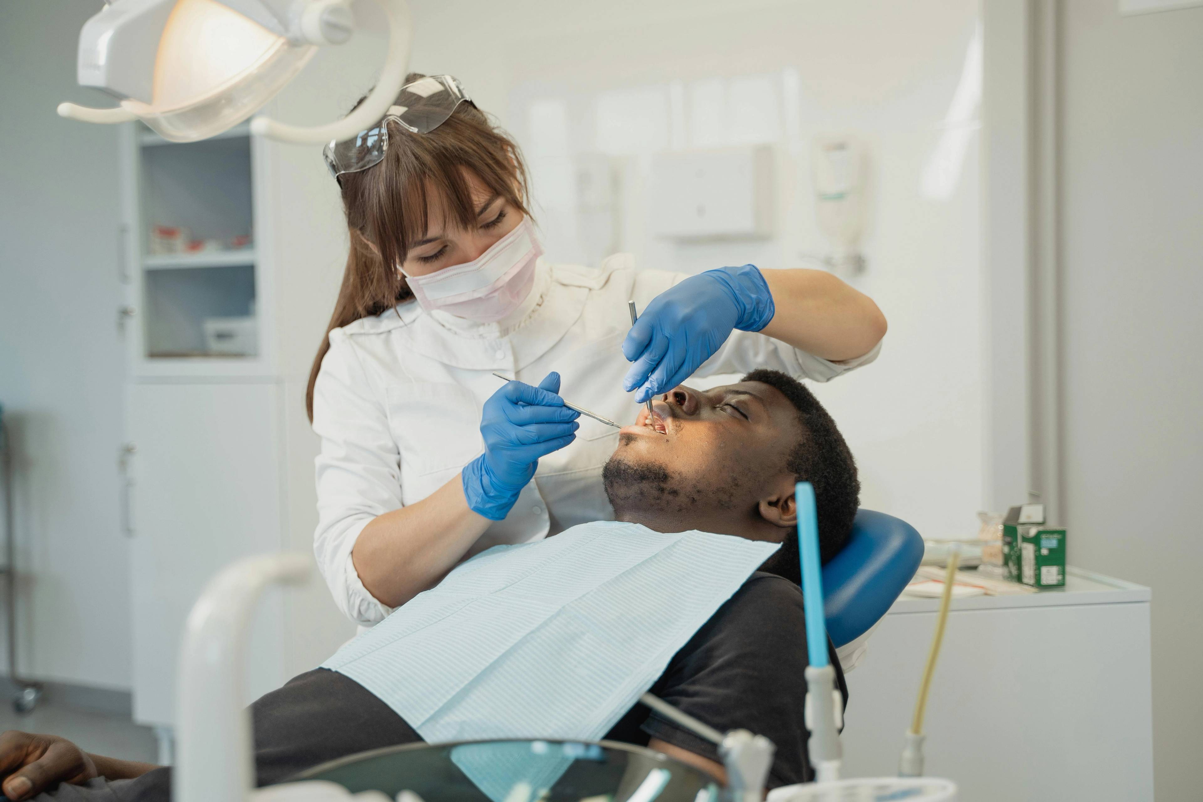 Dentist carrying out NHS dental check-up on patient in dental chair