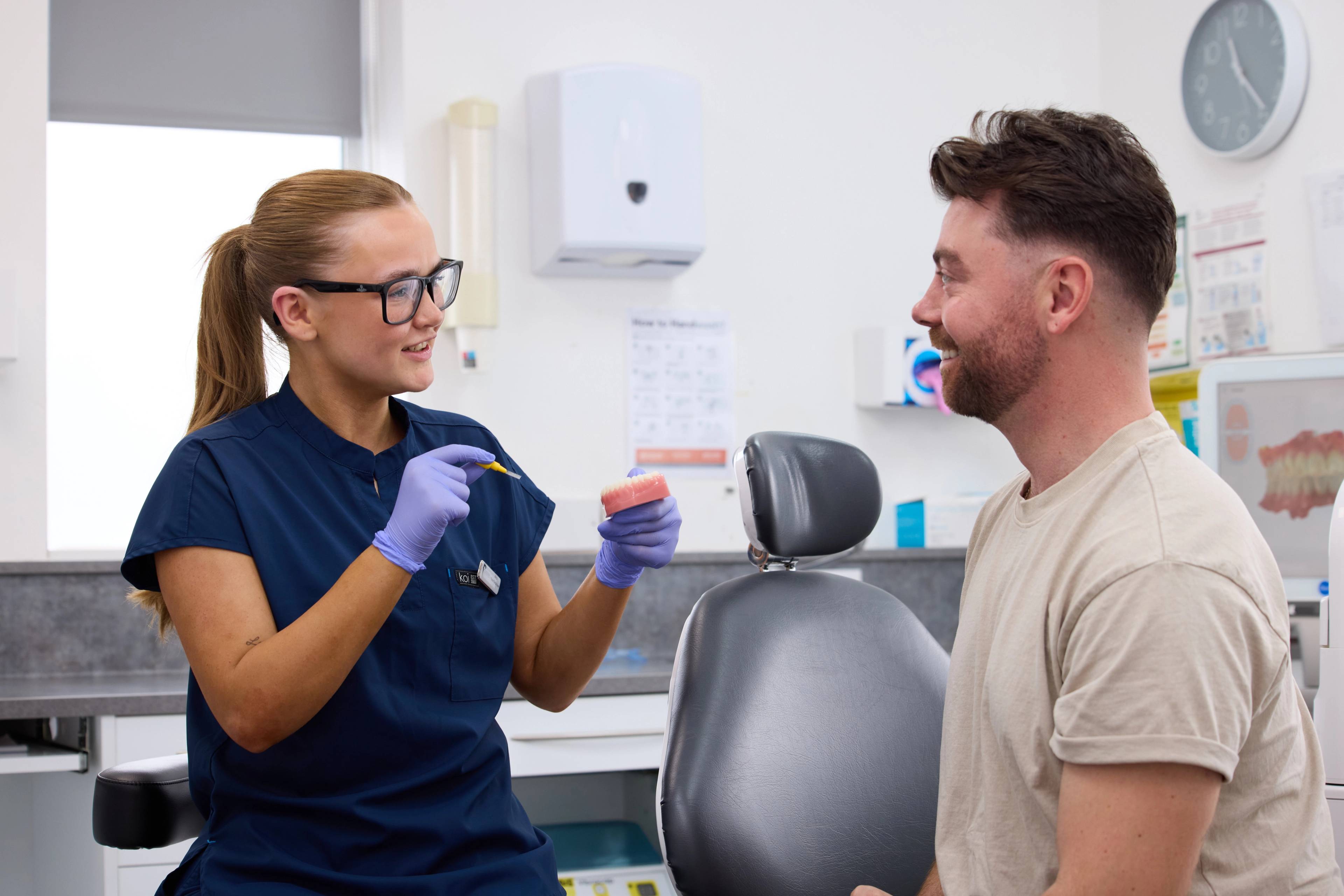 Precision Dental Clinic team in Oldham smiling stood in waiting room for a team photo