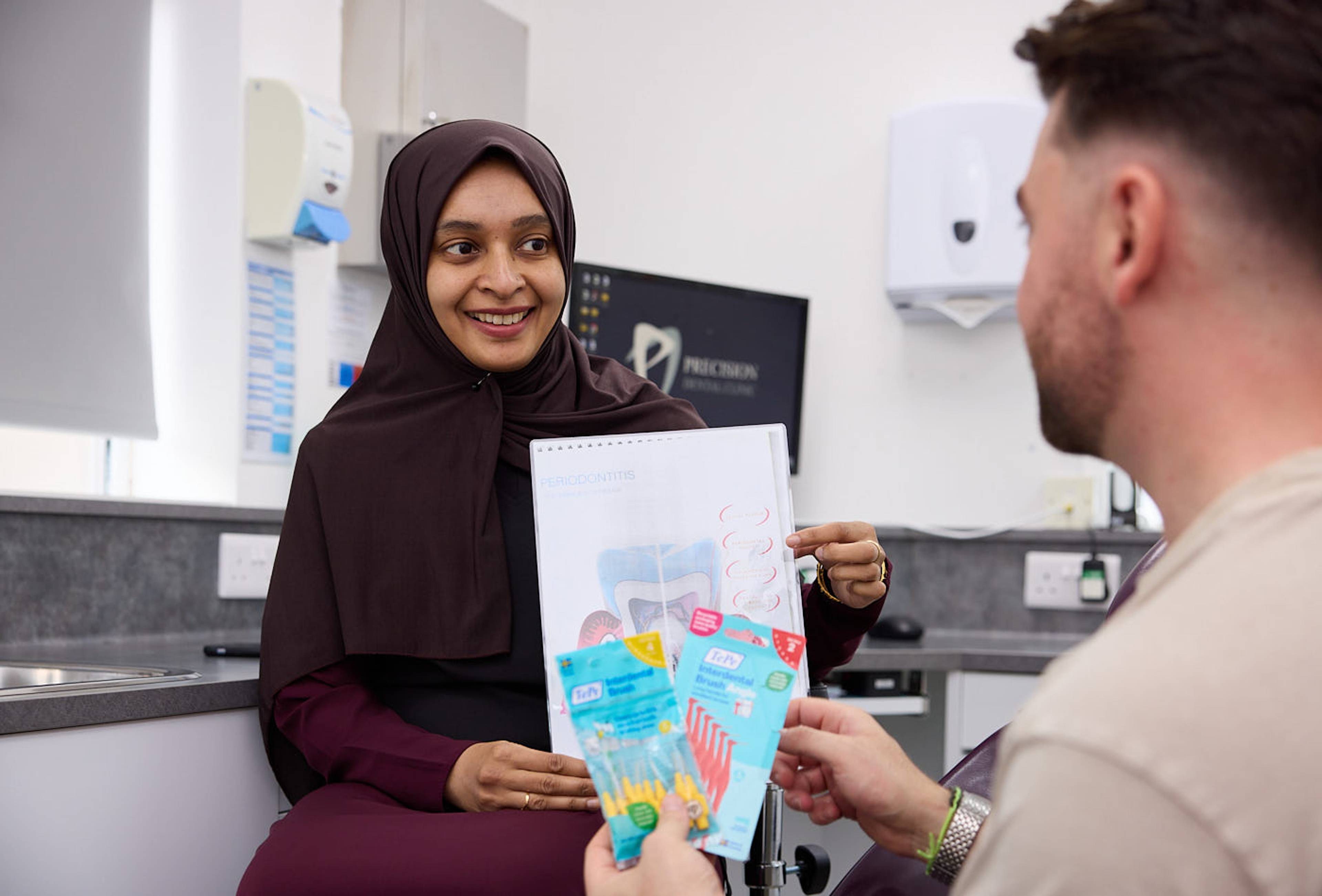 dental nurse speaking to patient in nhs dental appointment
